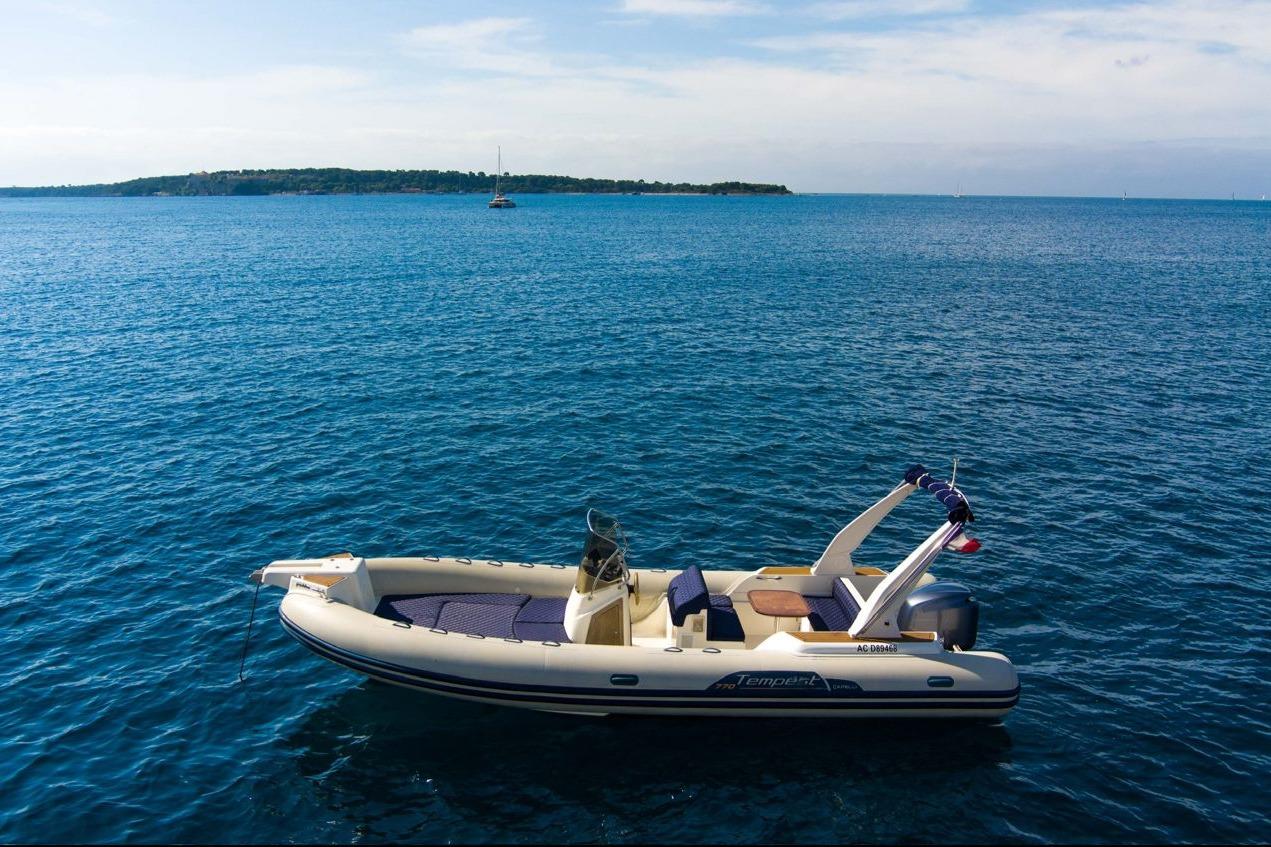 2020 Capelli Tempest 775 boat floating on calm blue sea with distant island.