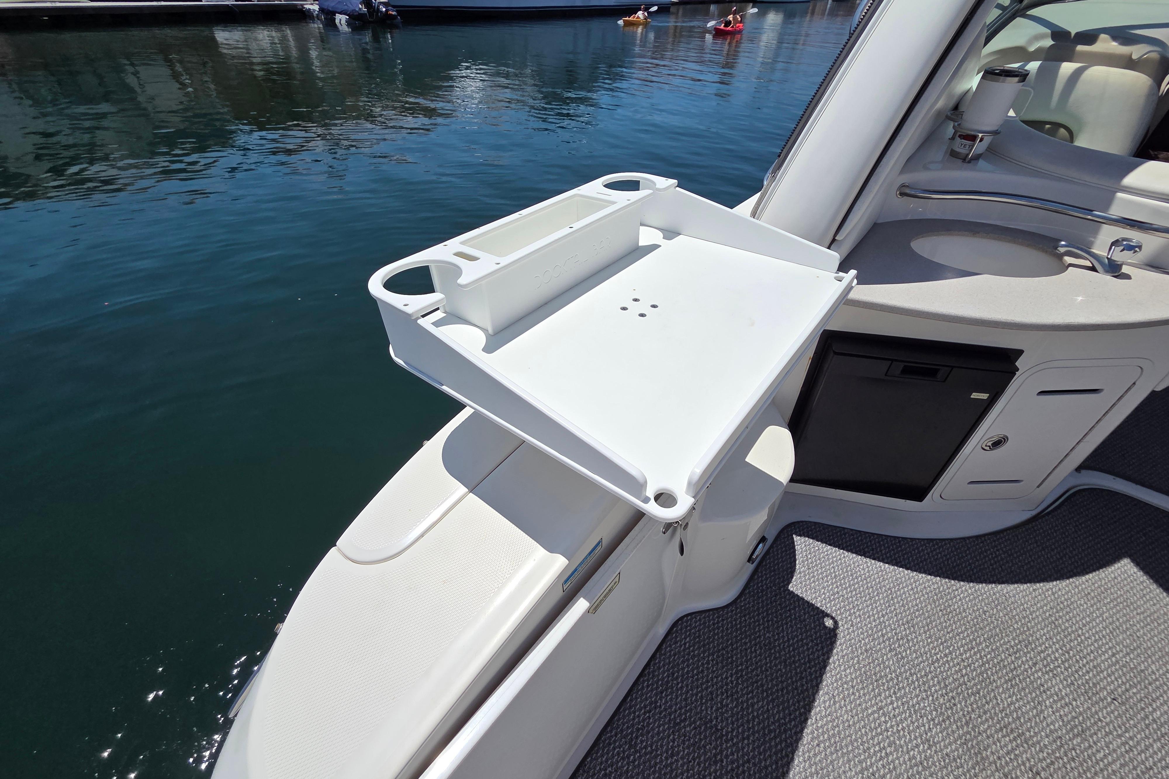2006 Sea Ray Sundancer 320 boat deck with a foldable table and water view.