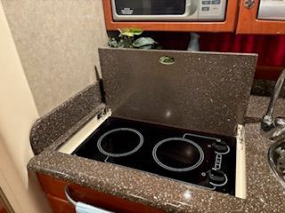 Galley with electric stove and microwave in a boat cabin.