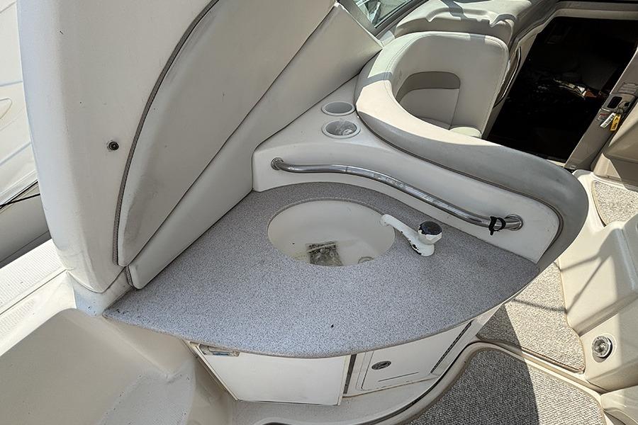 2002 Sea Ray Sundancer 320 boat interior with sink and seating area.