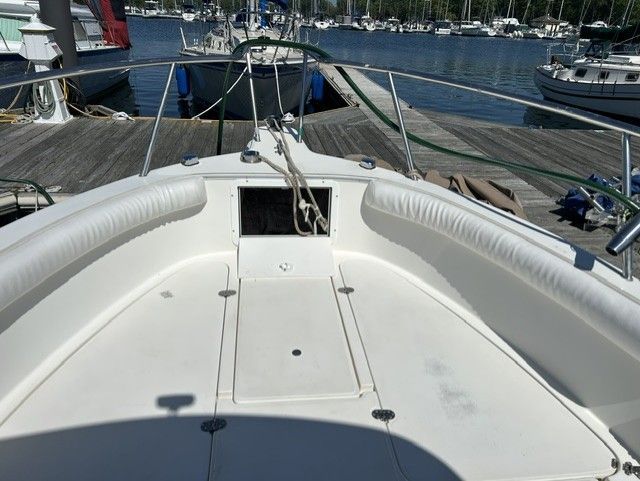 The image shows the bow area of an Aquasport Osprey 250 boat docked at a marina.