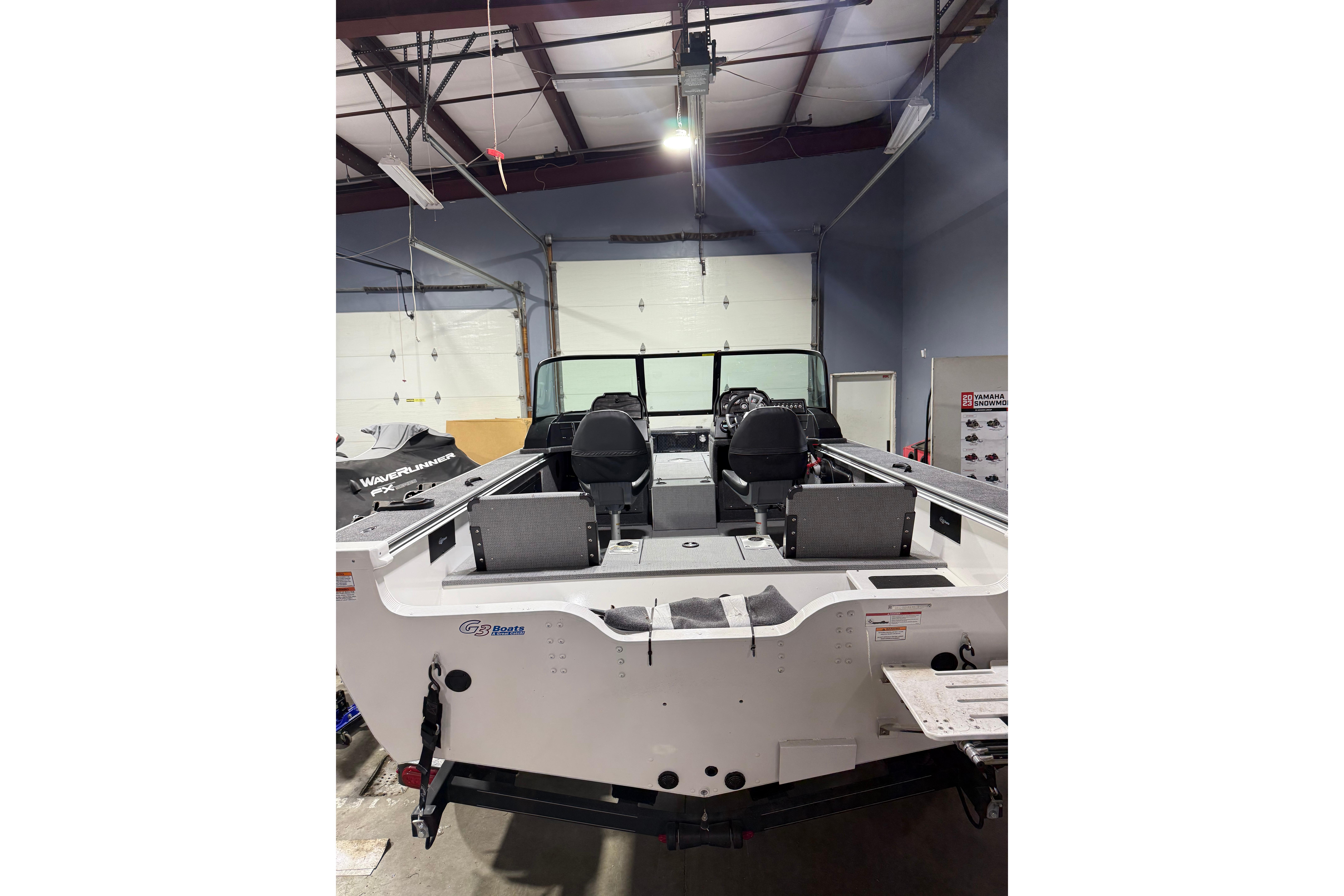 2025 G3 Angler V1850 SF boat in a showroom, rear view with seating and controls visible.