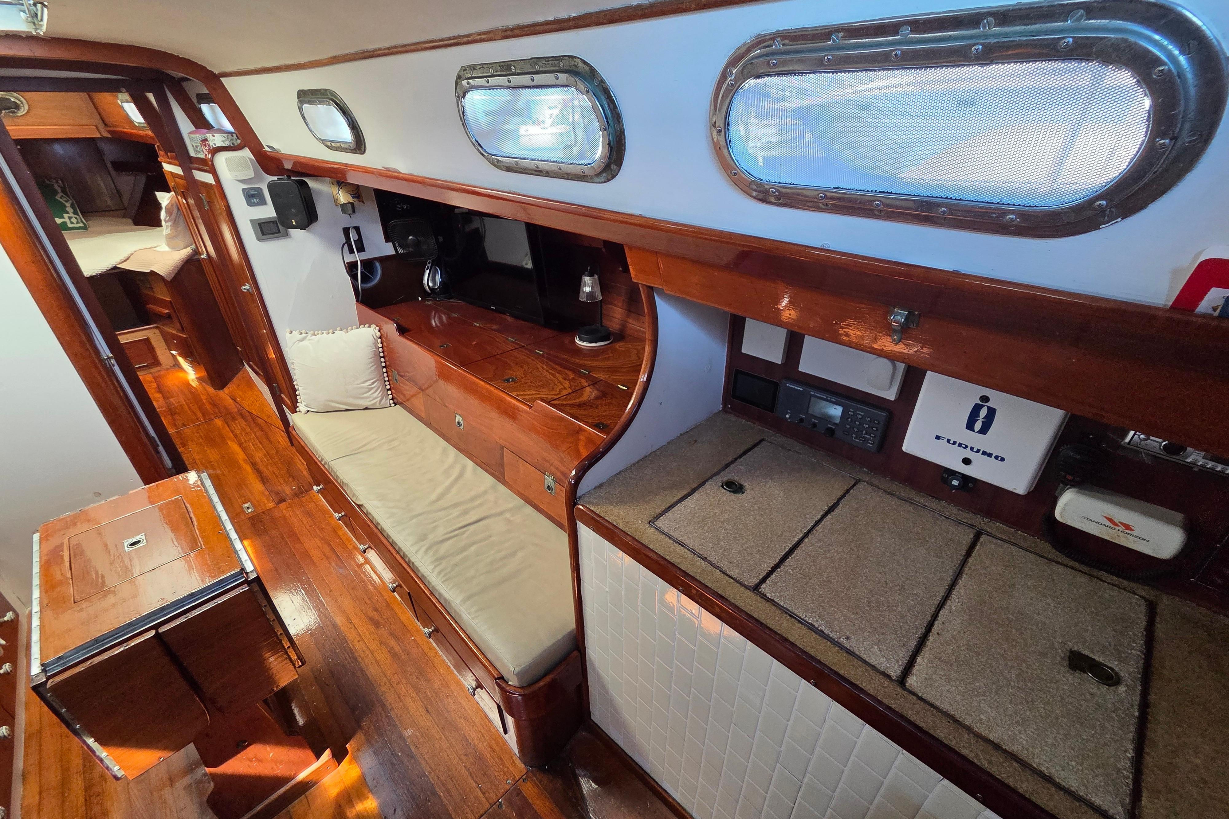 Interior of a 1961 Hinckley Bermuda 40 sailboat with wooden furnishings and cozy seating.