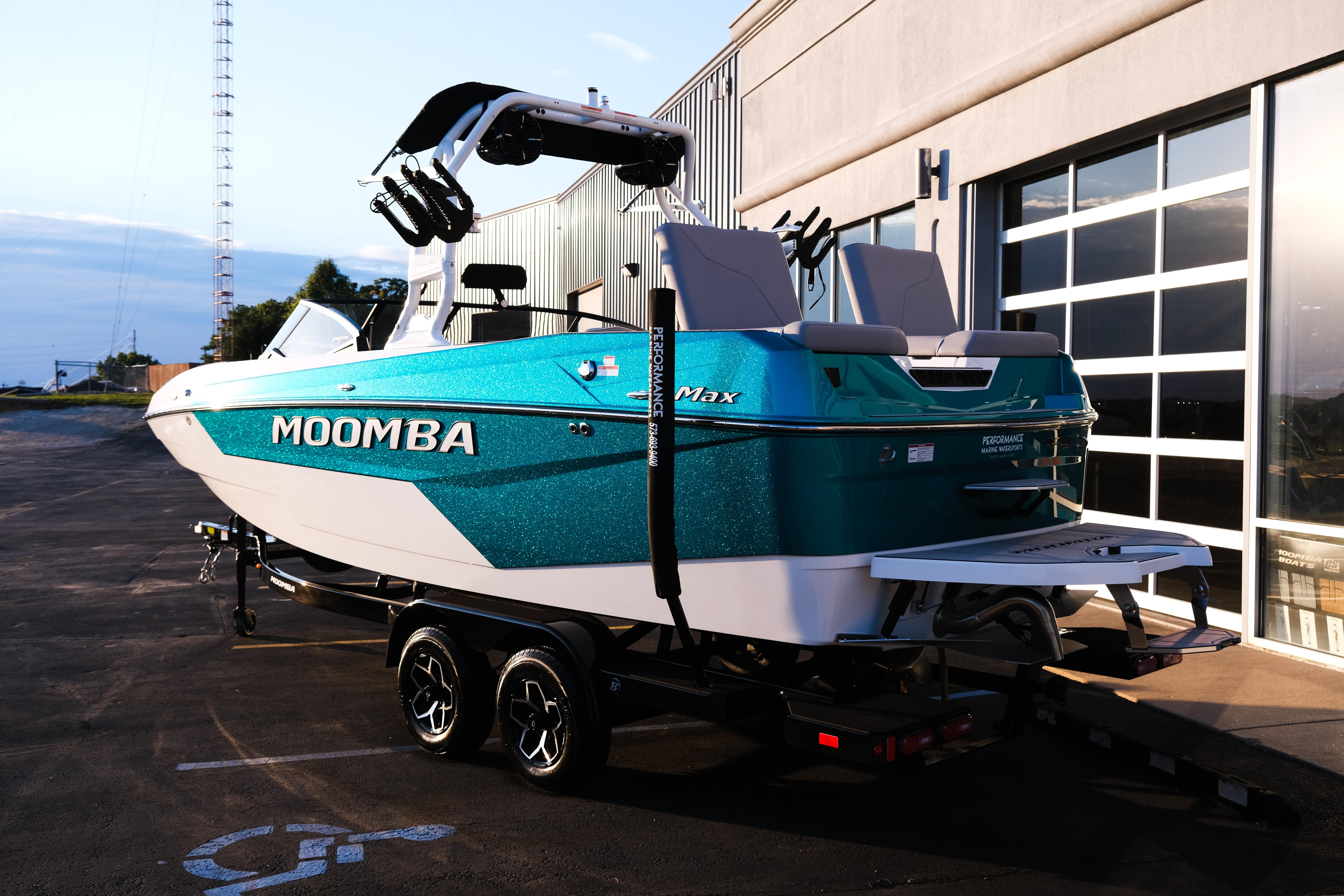 2026 Moomba Max boat on trailer, parked outside a building at sunset.