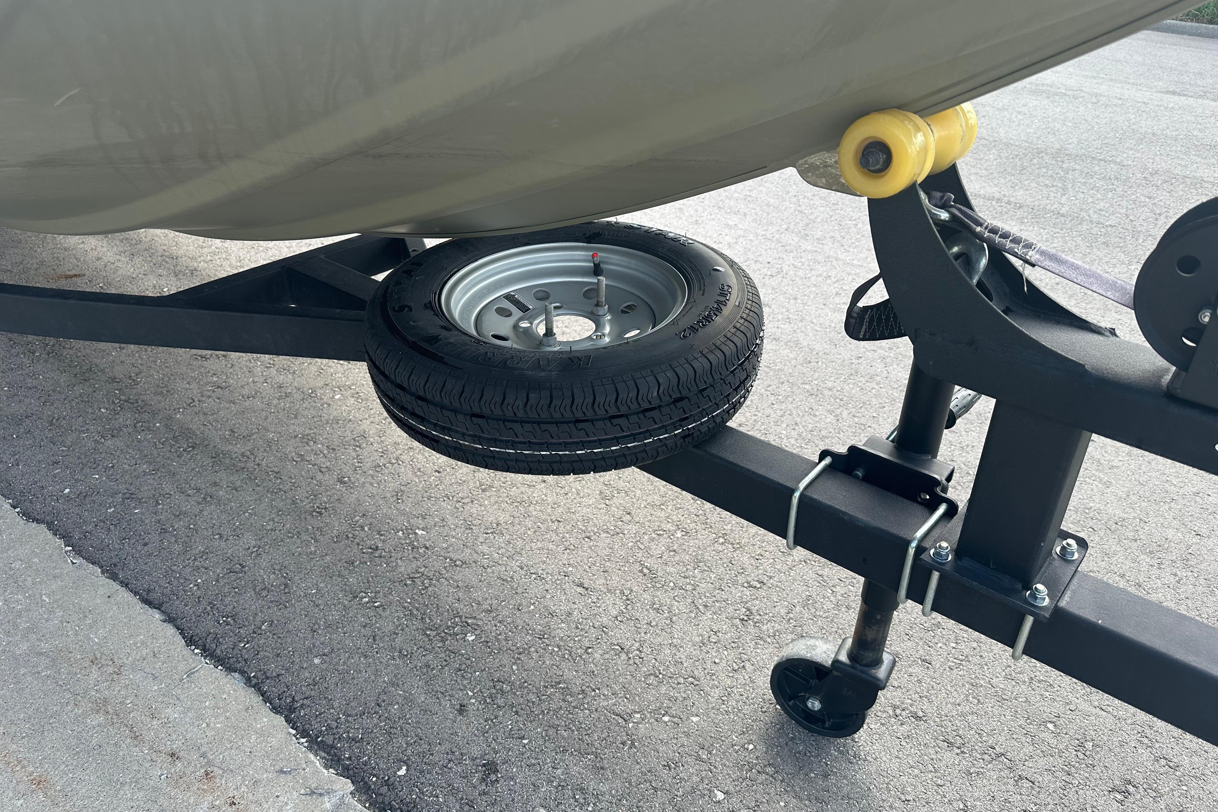 2024 Tracker Grizzly 1648 SC trailer with spare tire on asphalt.
