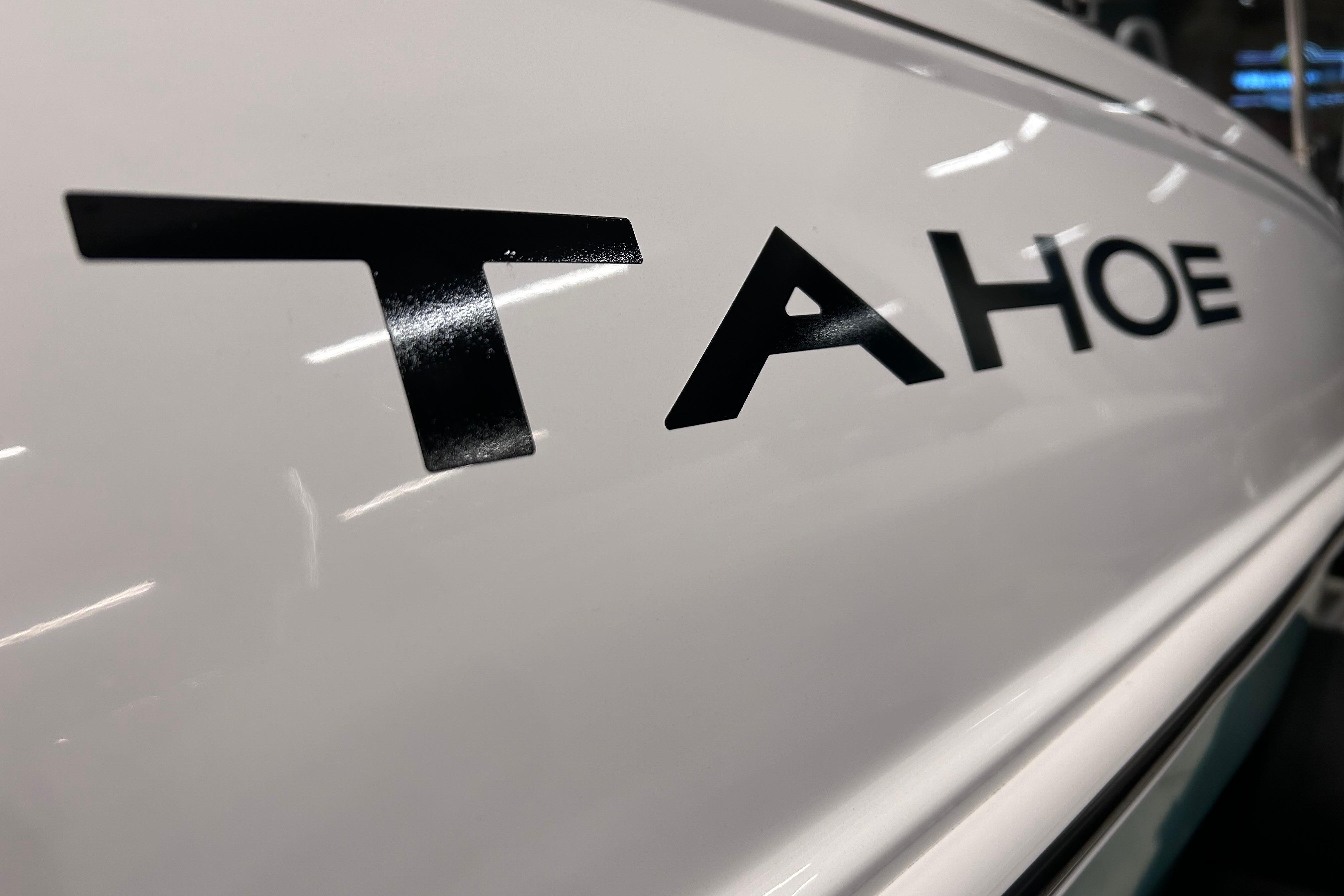 Close-up of 2026 Tahoe T18 boat logo on white surface.