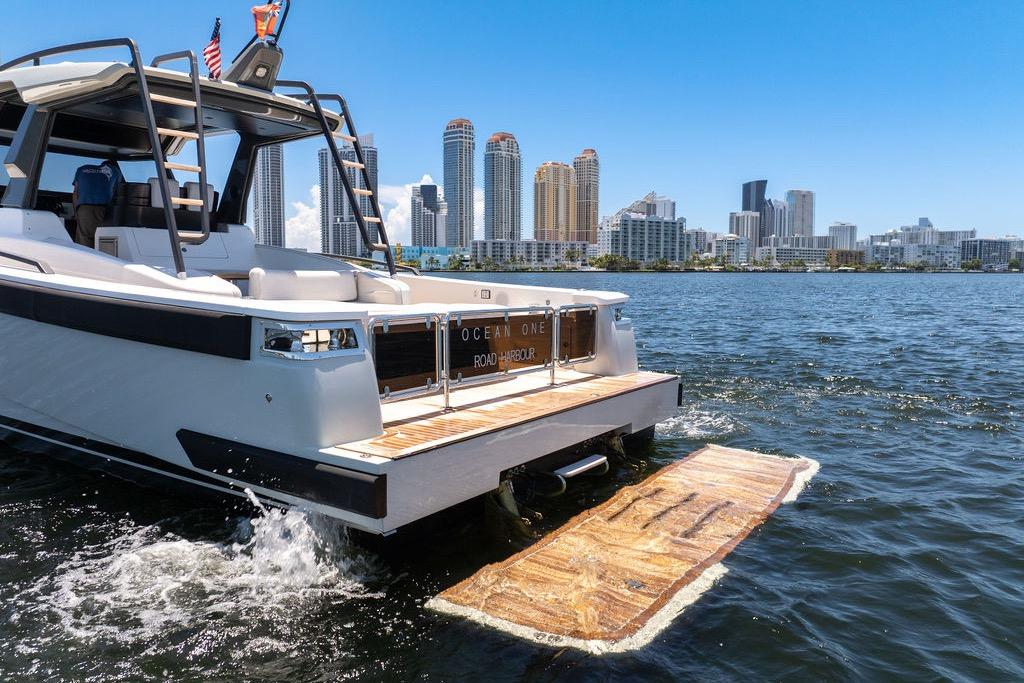 2021 Bluegame BG 42 yacht cruising near city skyline on a sunny day.