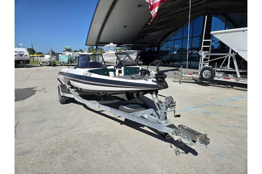 1997 Javelin 389 FS boat on trailer, parked outdoors near a modern building.