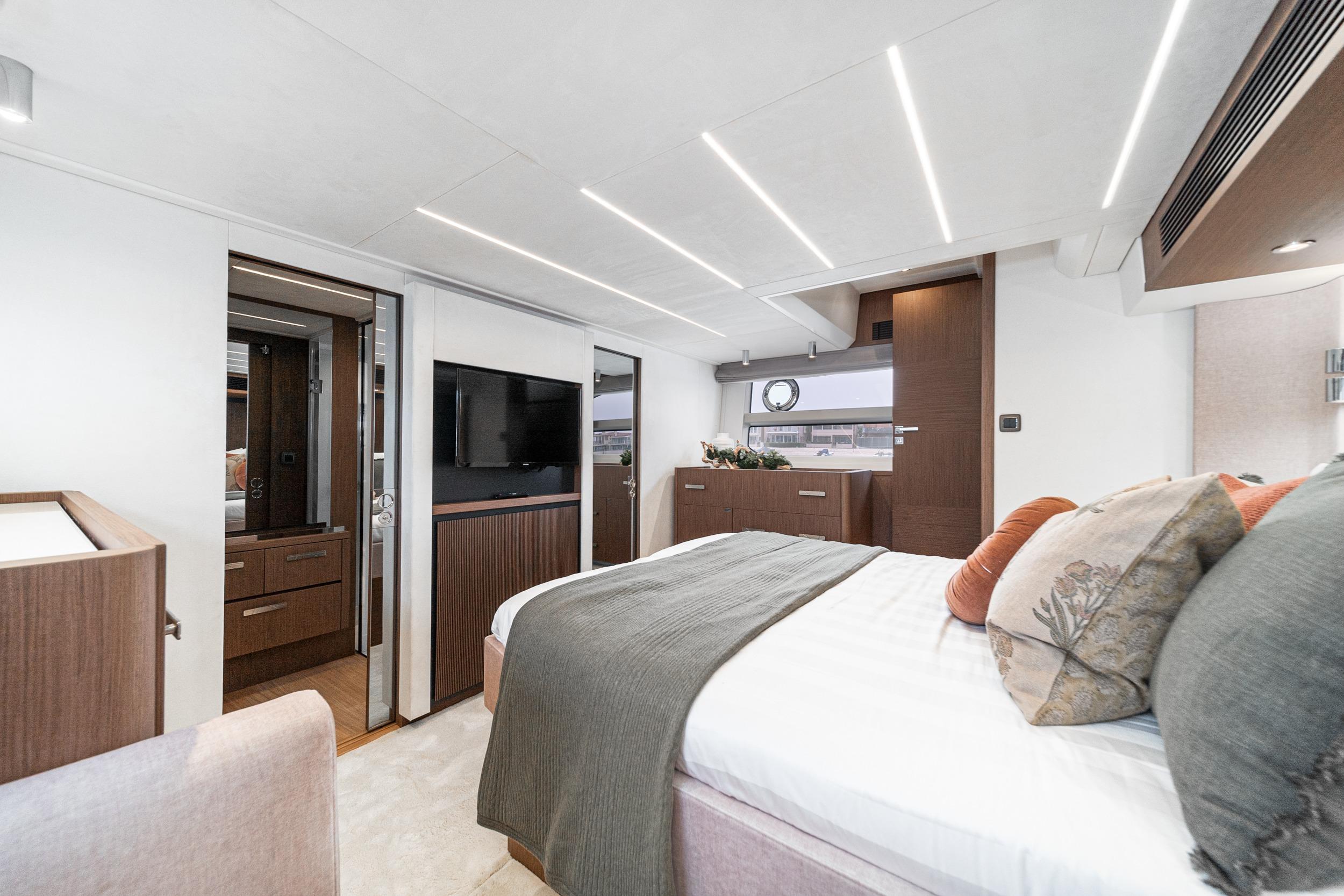 Luxurious 2024 Prestige X60 yacht bedroom with modern decor and ambient lighting.