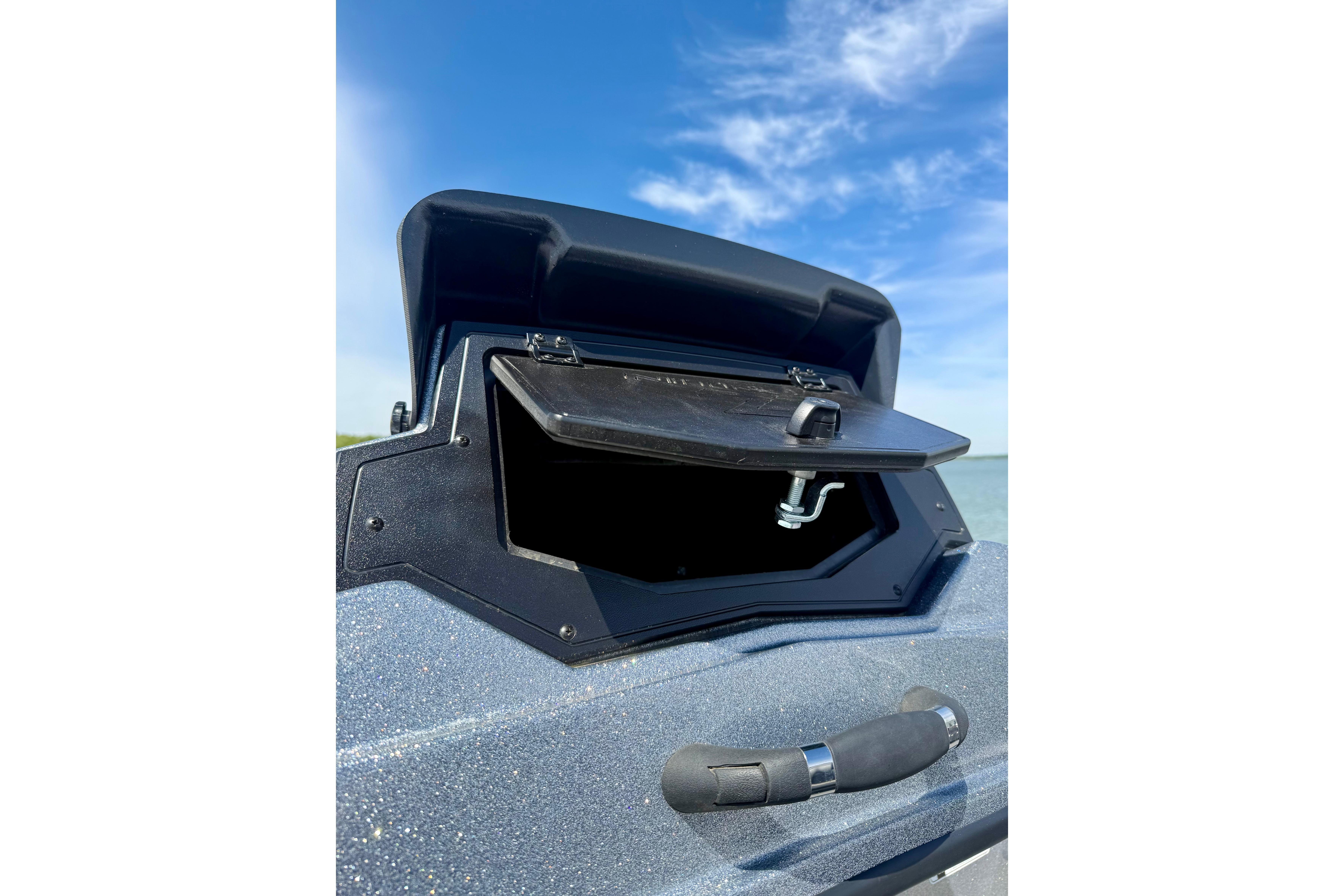 Open storage compartment on 2026 Nitro Z19 XL boat under a clear blue sky.