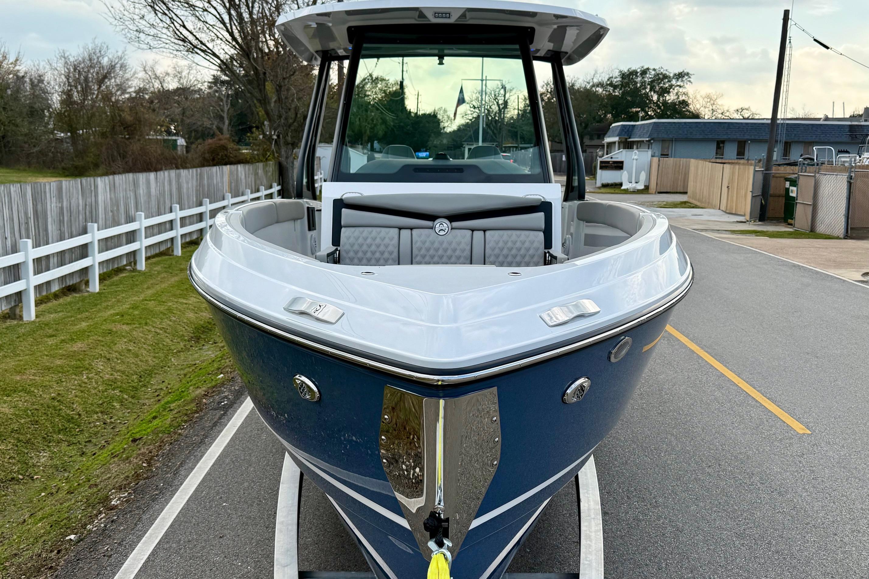 2026 Monterey Elite 25 OB boat on trailer, parked on a residential street.