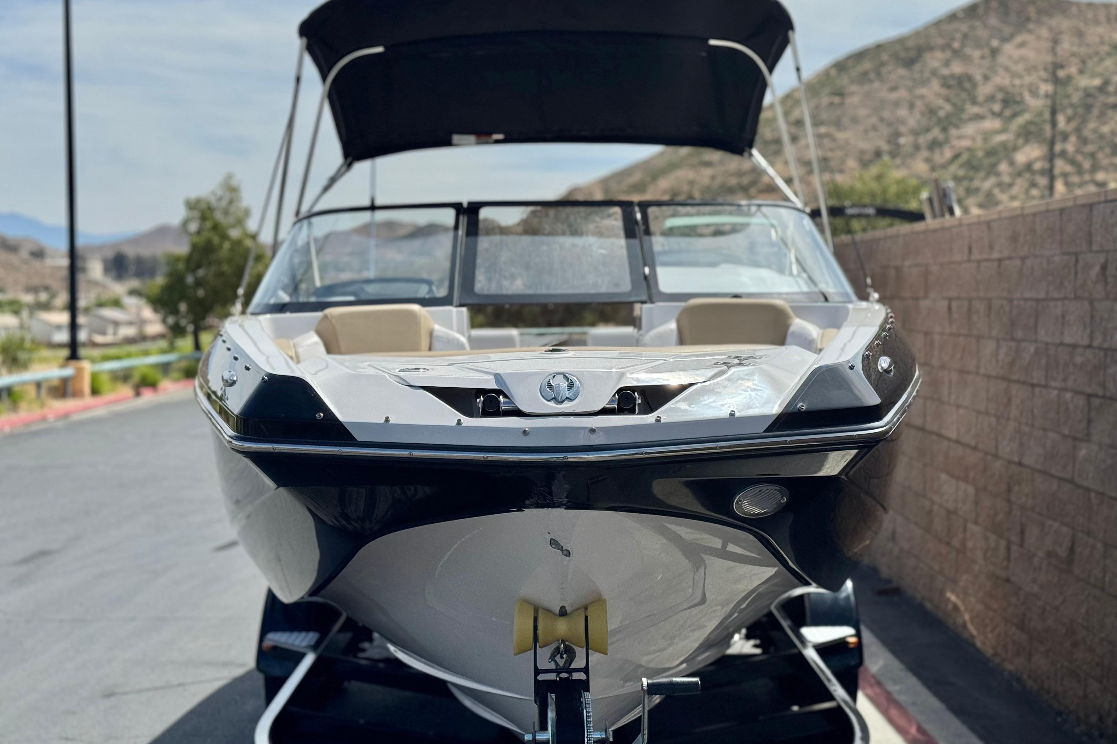 2017 Scarab 255 H.O. Platinum boat on trailer, parked near a brick wall.
