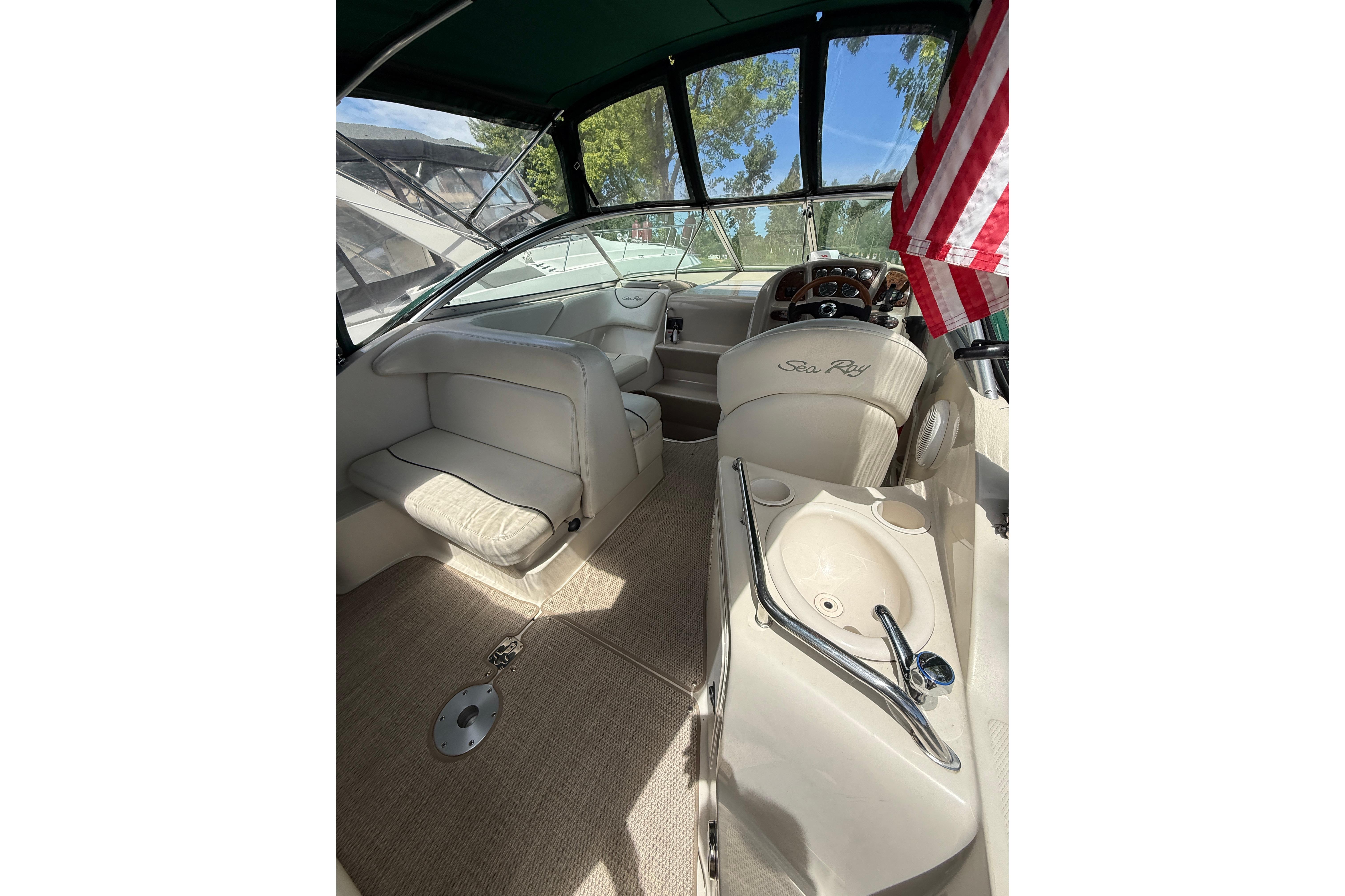 Interior of a 2004 Sea Ray 240 Sundancer boat with seating and steering wheel.
