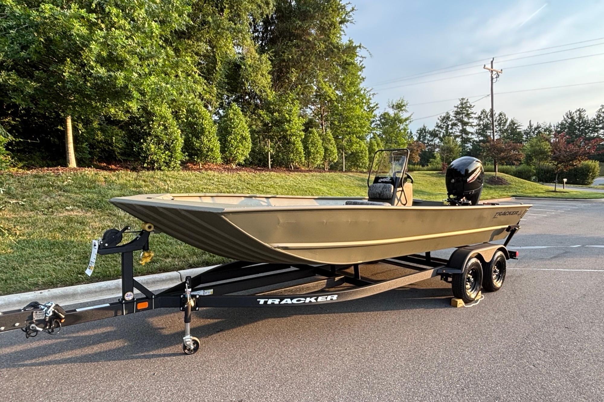 2026 Tracker Grizzly 2072 CC boat on trailer, parked on a road near greenery.