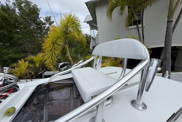 2025 Contender 26 Bay boat with white seating, surrounded by tropical palm trees.