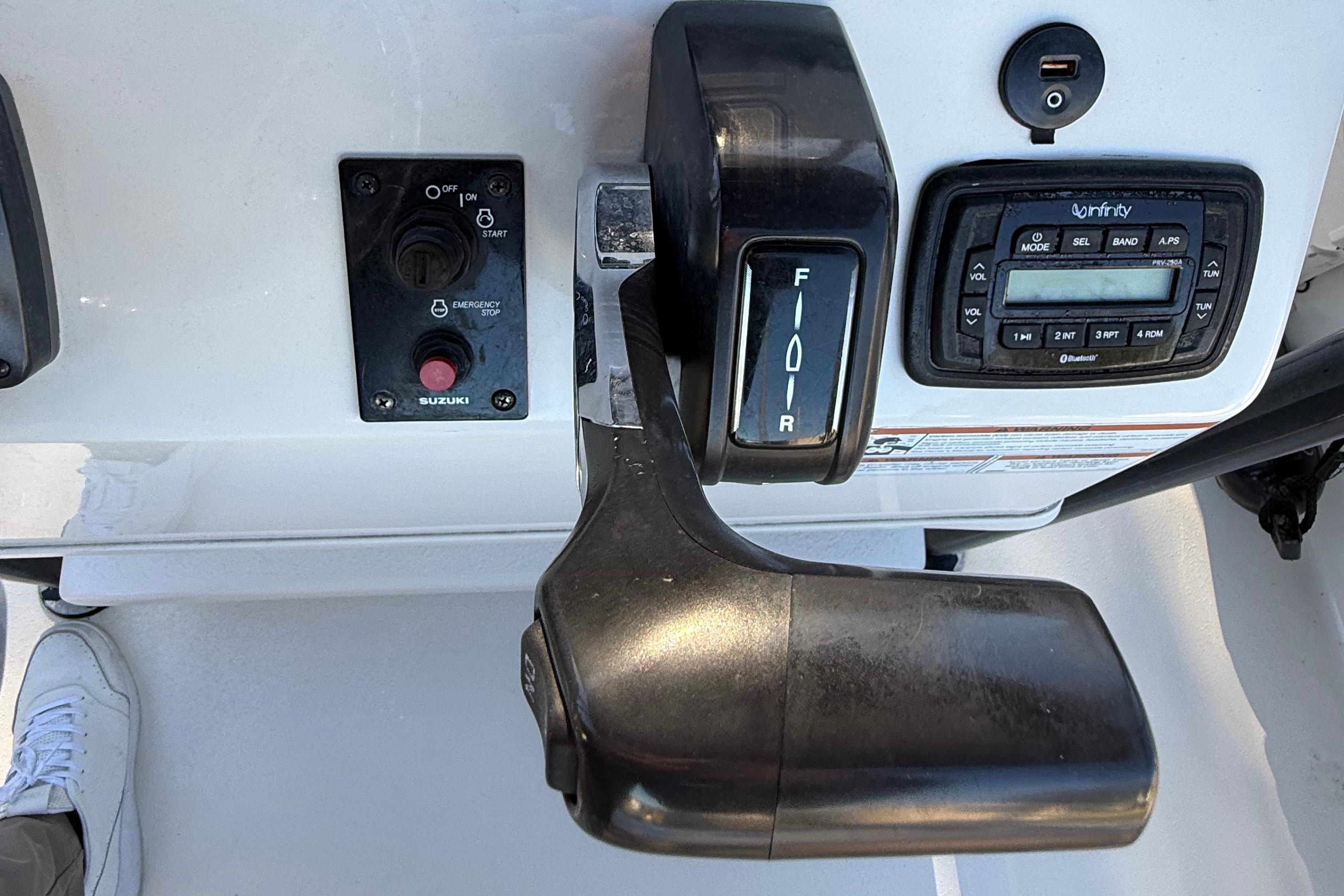Control panel of a 2021 Carolina Skiff 26 Ultra Elite boat with throttle and audio system.