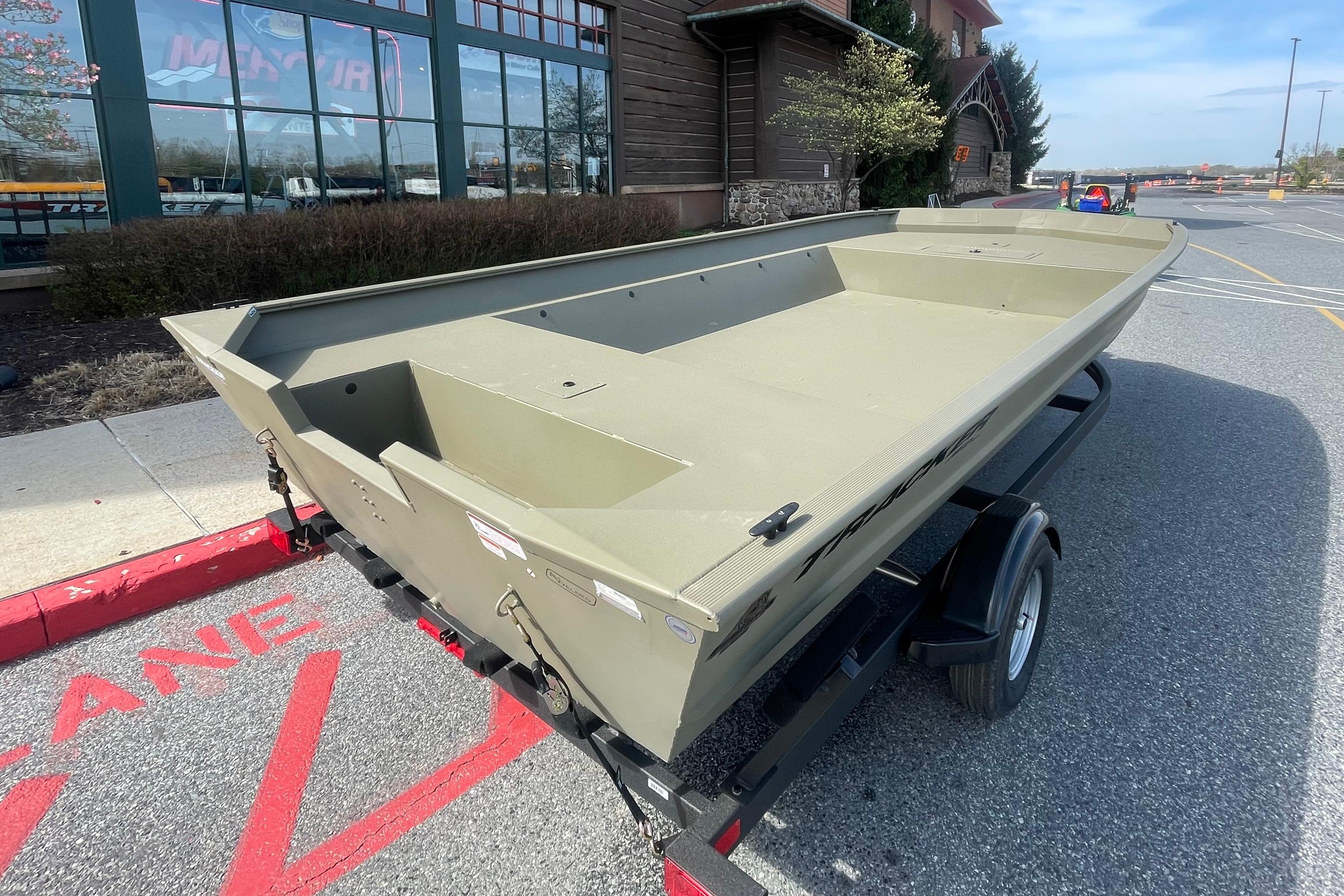 2026 Tracker Grizzly 2072 Utility boat on trailer in parking lot.