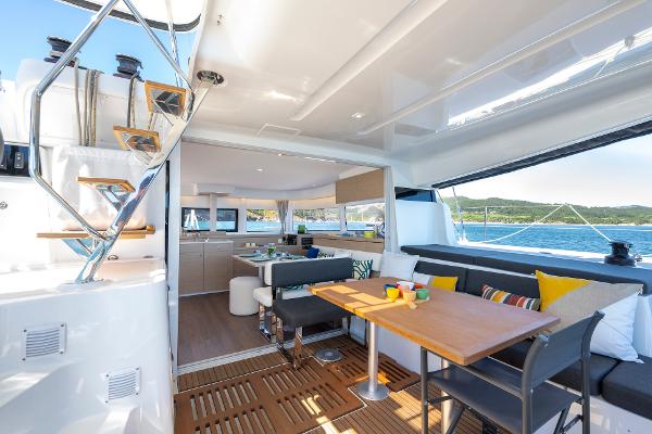 Luxurious Lagoon 43 yacht interior, 2025 model, featuring modern seating and dining area with ocean view.