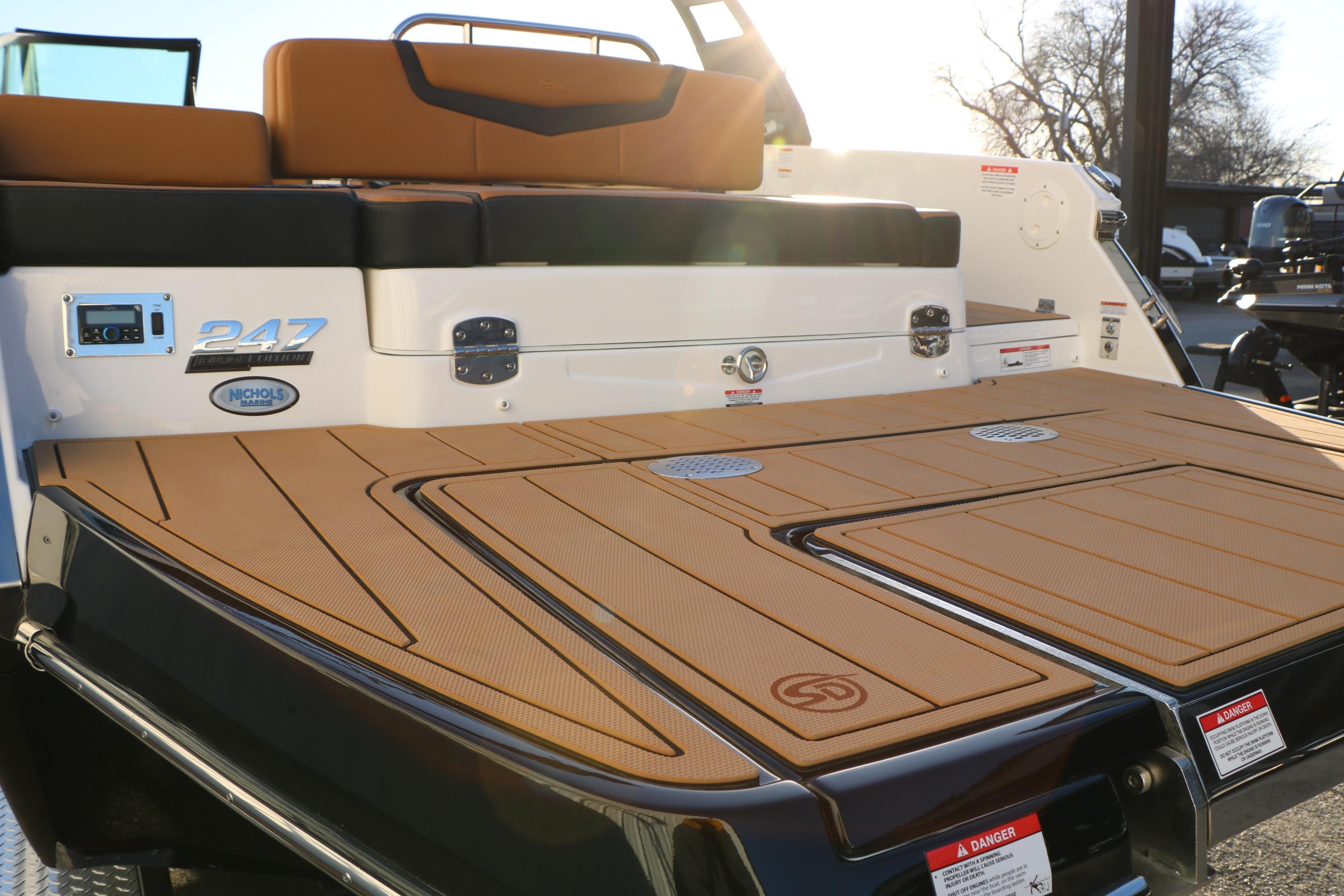 2026 Chaparral 247 SSX boat with tan deck and seating, rear view.