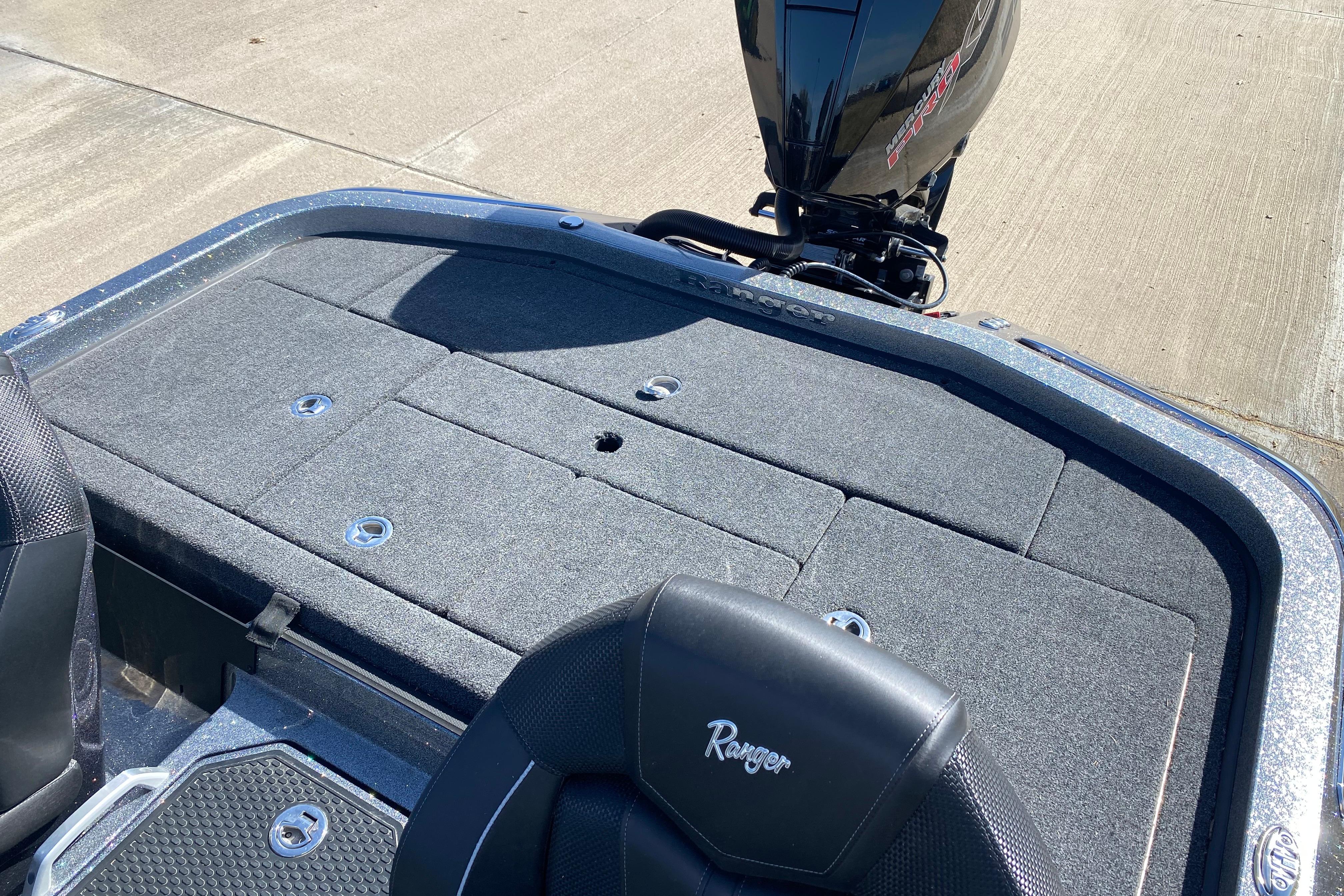2025 Ranger Z520 boat deck with storage compartments and motor, parked on concrete.