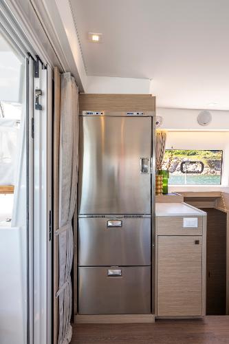 Modern kitchen area in a 2025 Lagoon 43 yacht, featuring sleek stainless steel appliances.