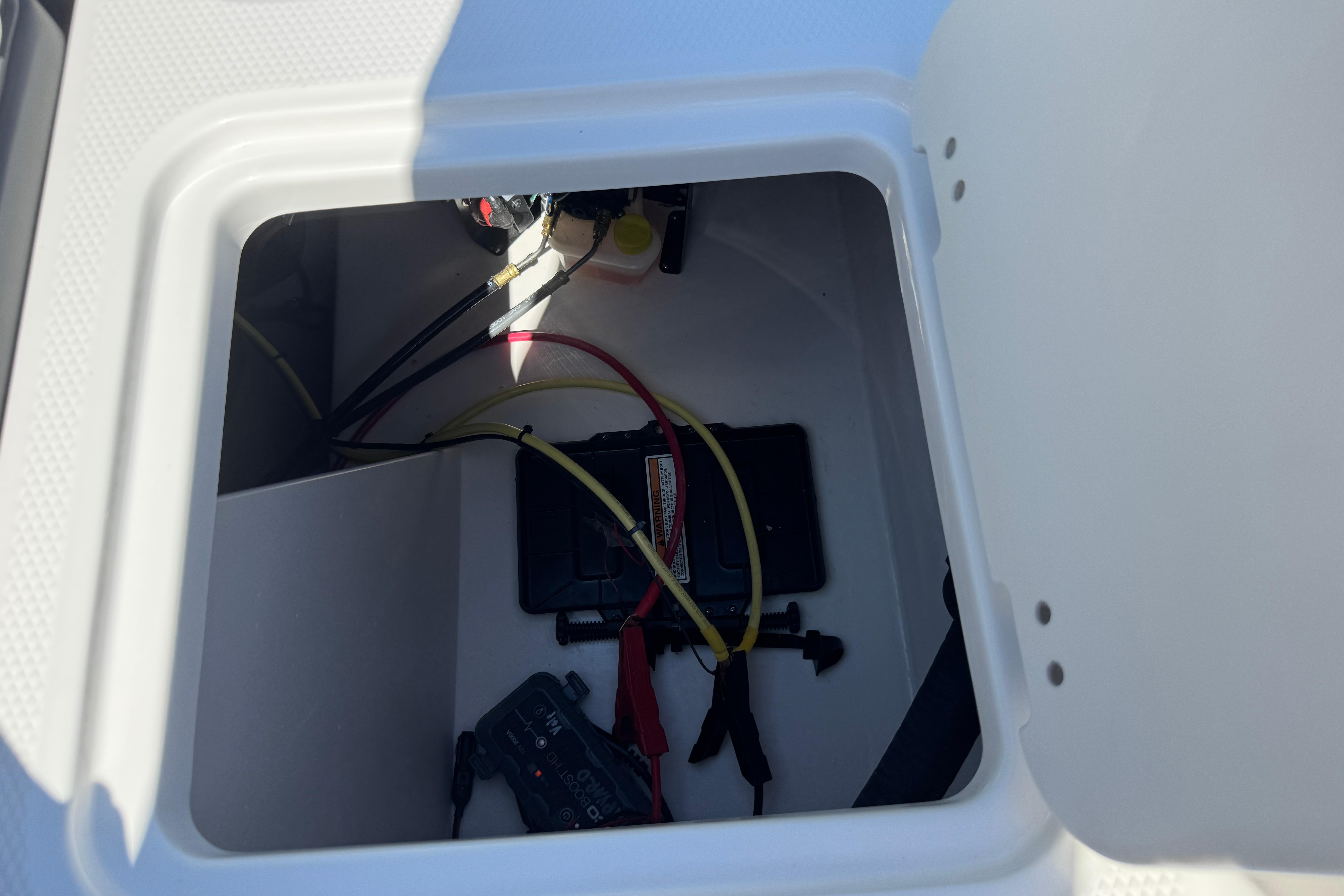 Battery compartment of 2026 Chaparral 21 SSi boat, showing wiring and connections.