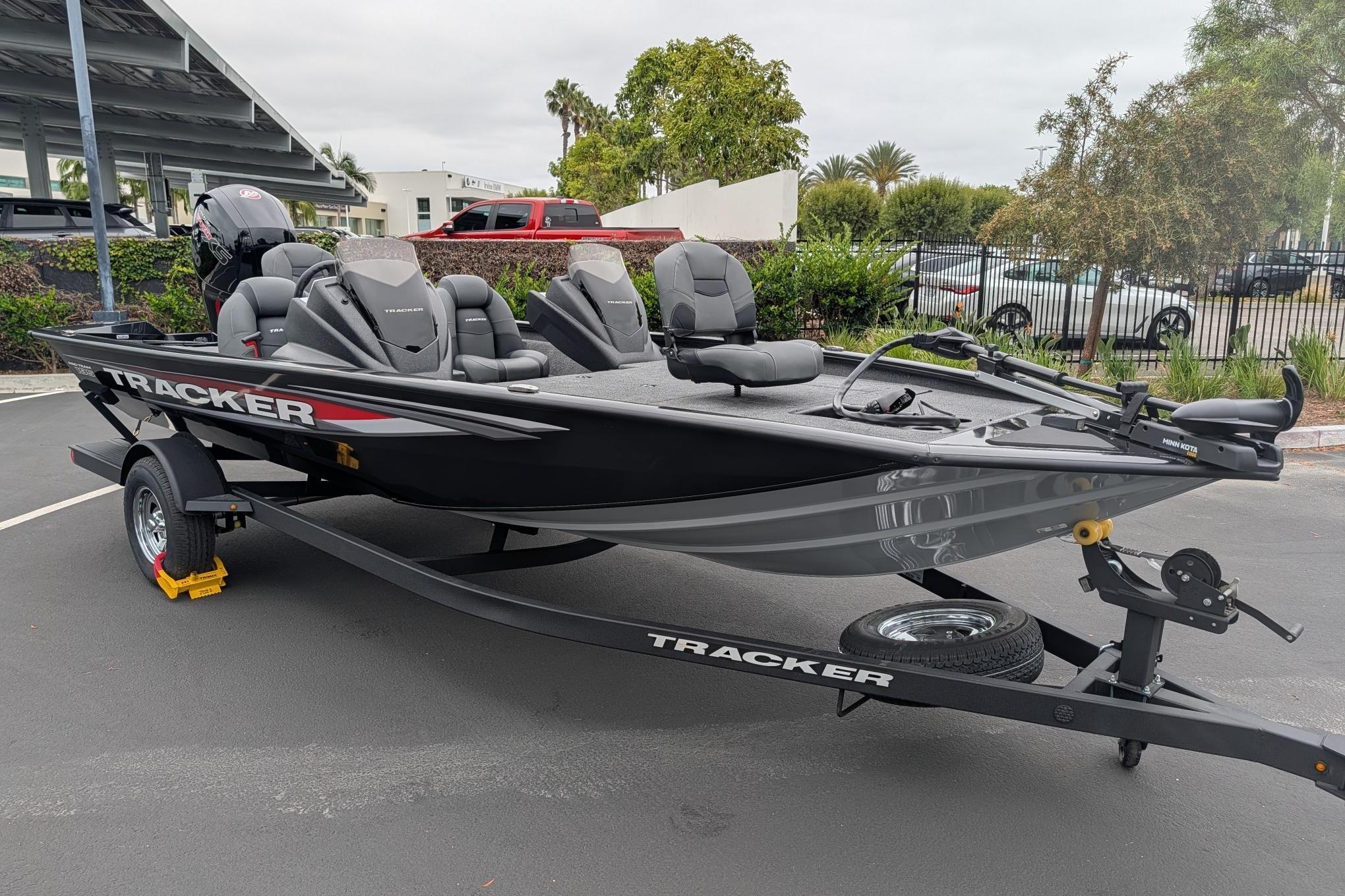 2026 Tracker Pro Team 195 TXW fishing boat on trailer in parking lot.