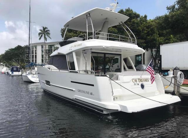 2022 Greenline 48 Flybridge yacht with hardtop docked, featuring sleek design and American flag.