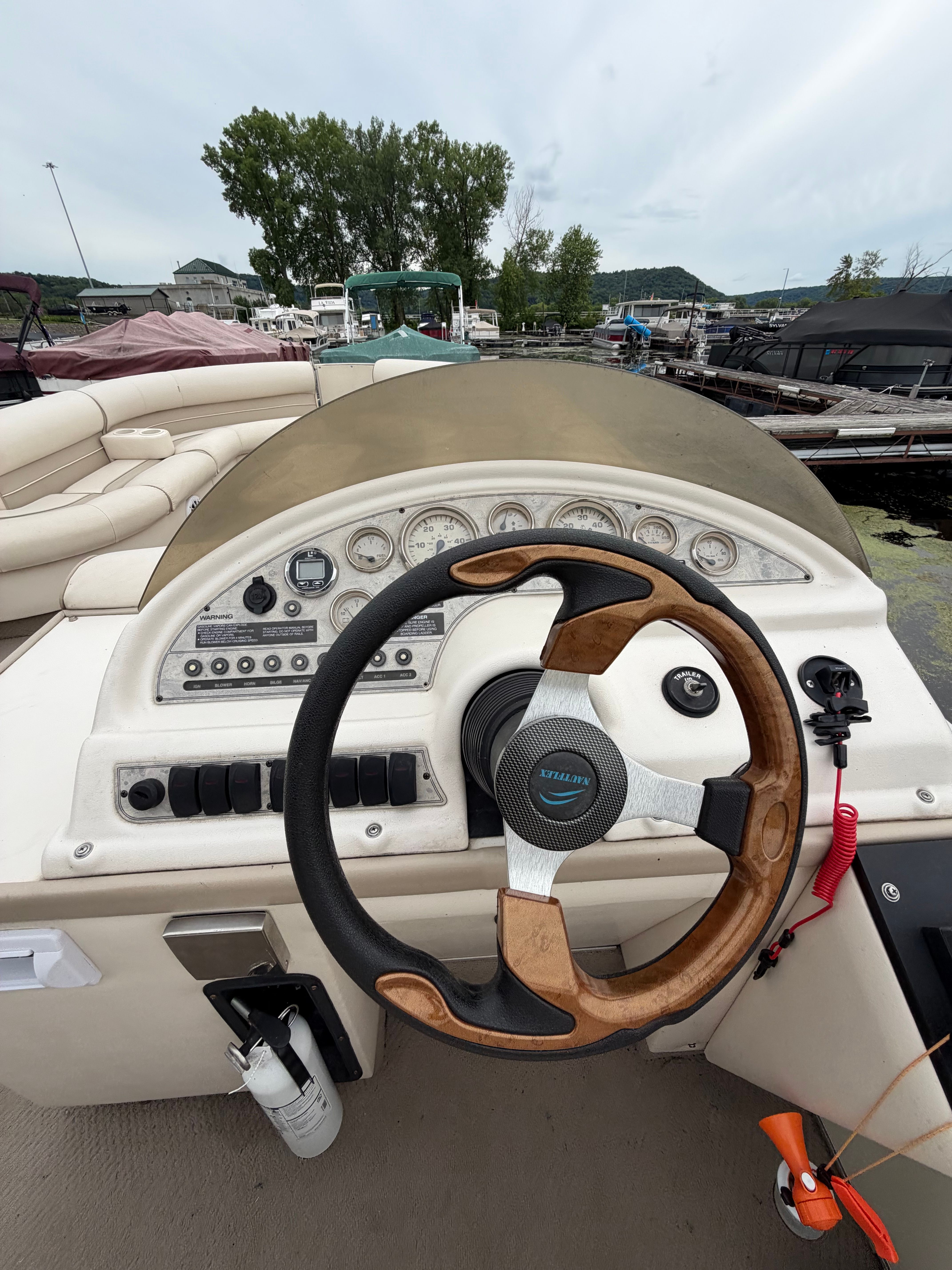 Helm of a 2000 Crest Grand Caribbean with a wooden steering wheel and instruments.