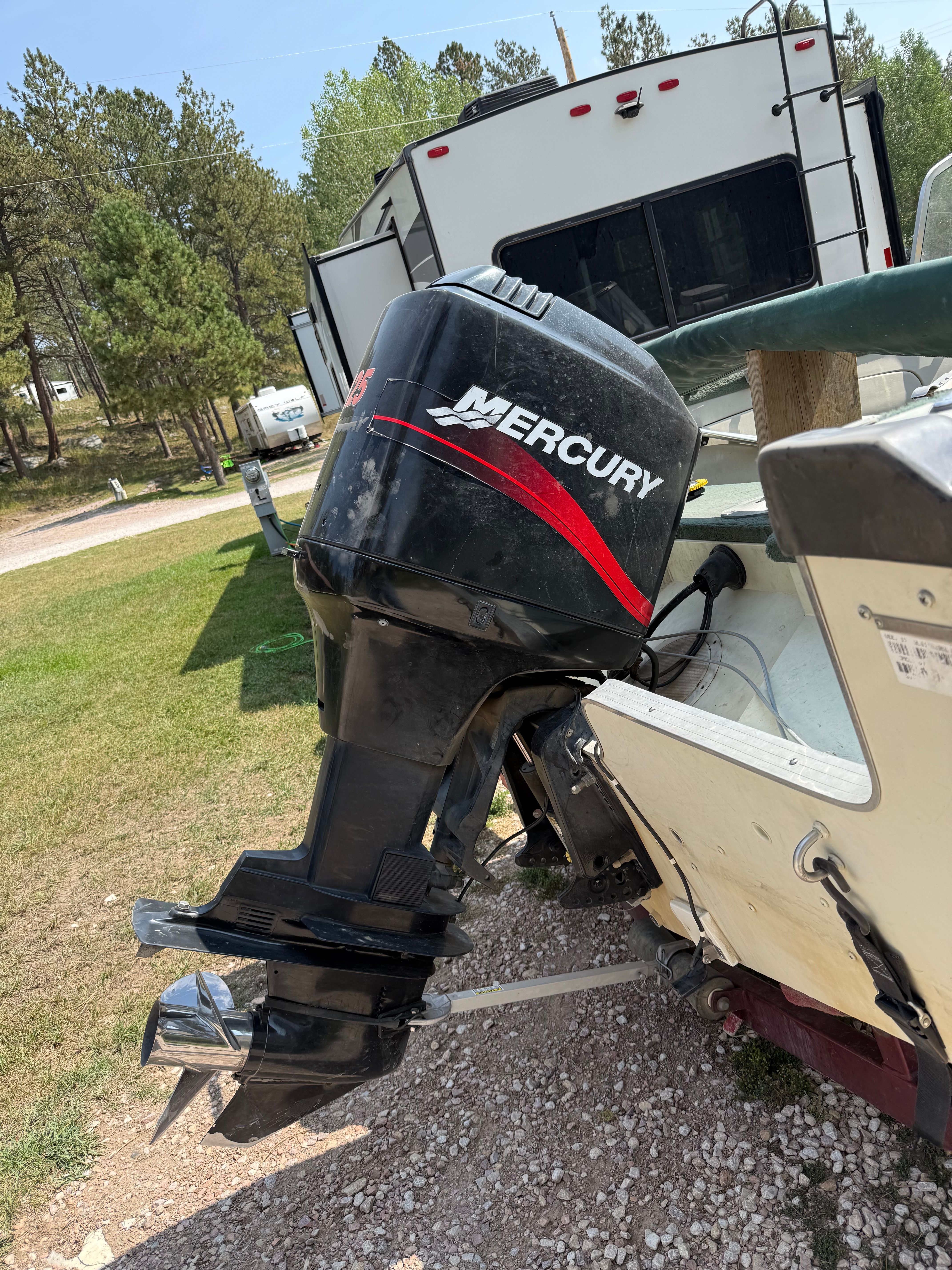 Outboard motor of a 1999 Lowe Roughneck boat on a trailer.