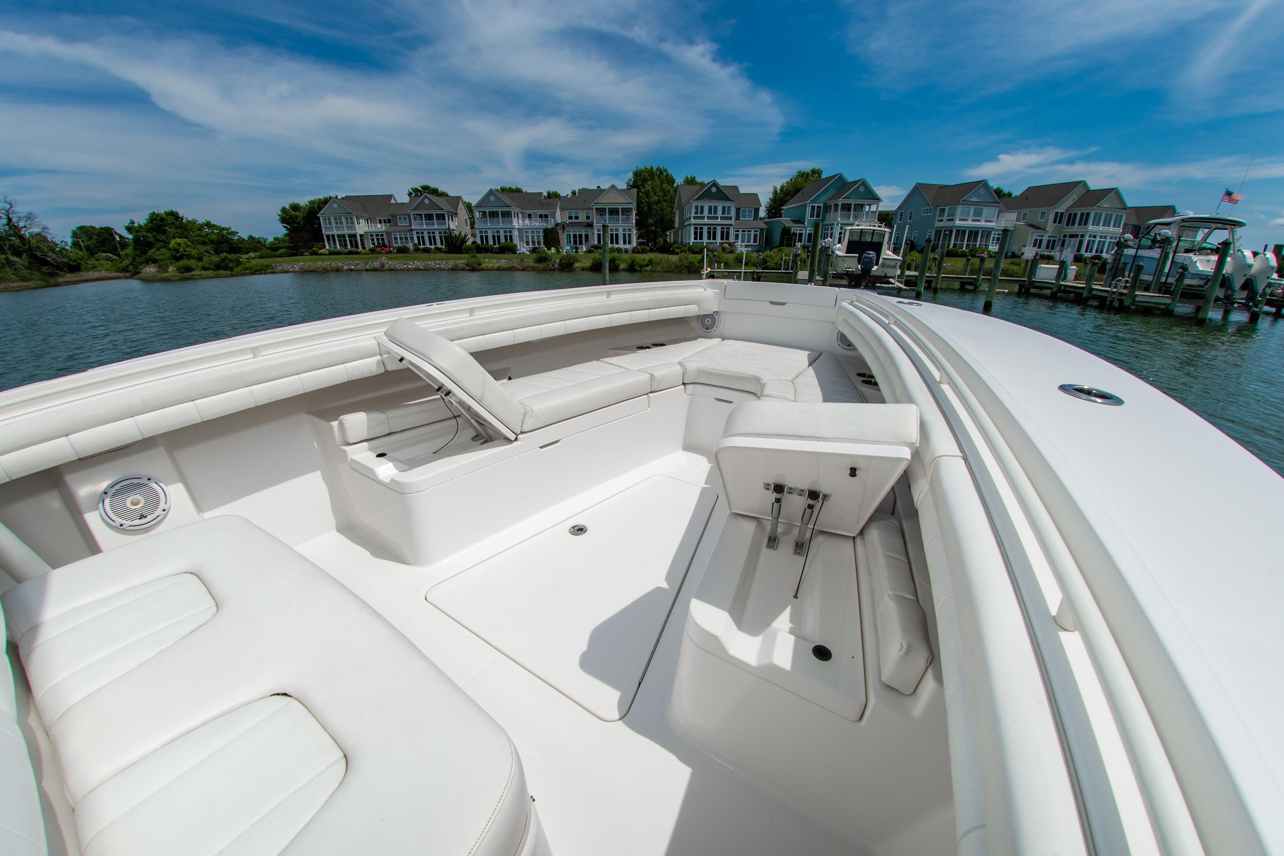 2019 Regulator 31 boat interior with white seating, docked near waterfront homes.