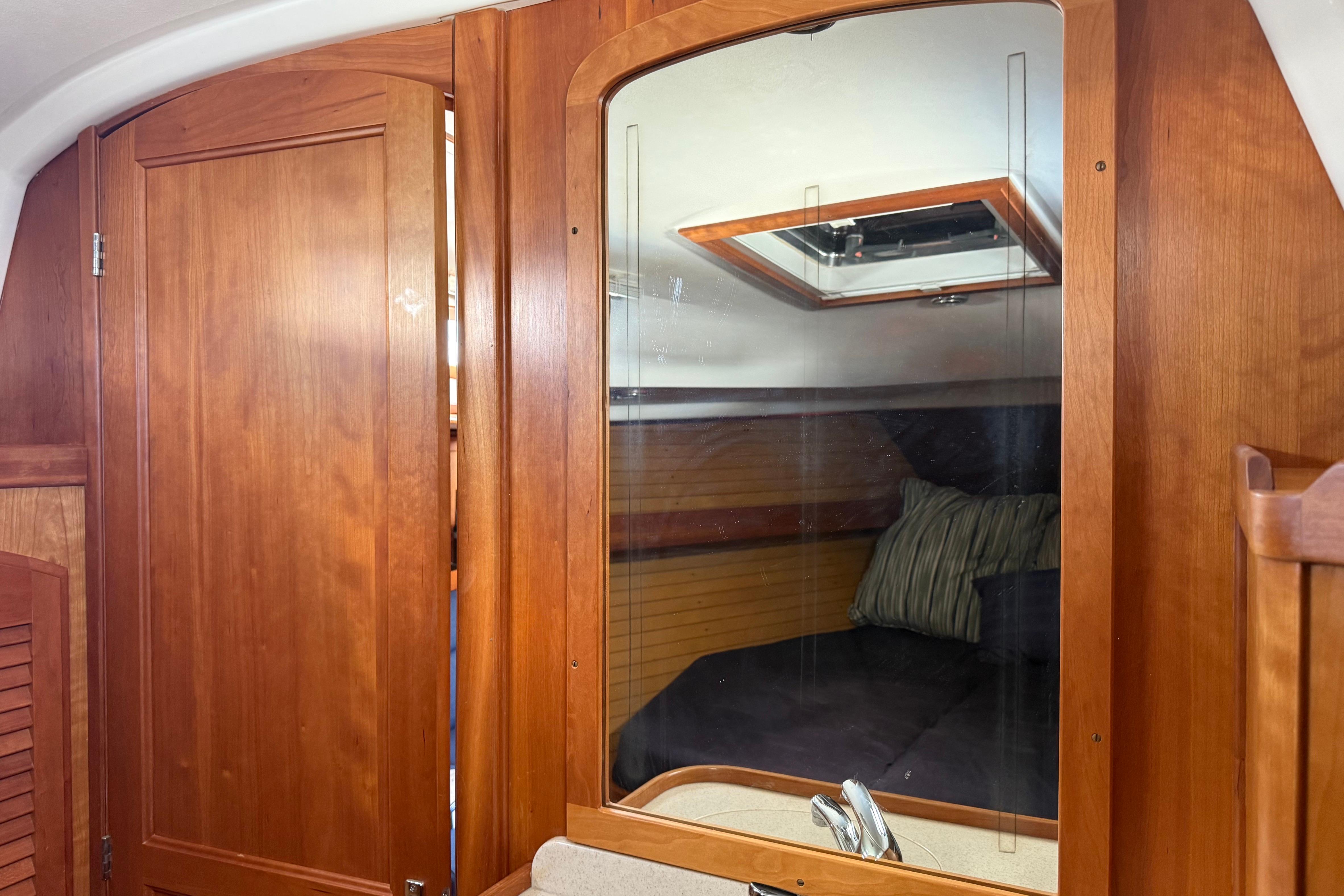 Interior of 2004 Sabre 386 sailboat with wooden cabinetry and cozy sleeping area.
