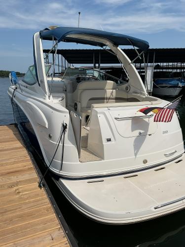 2008 Chaparral Signature 310 boat docked with flags.