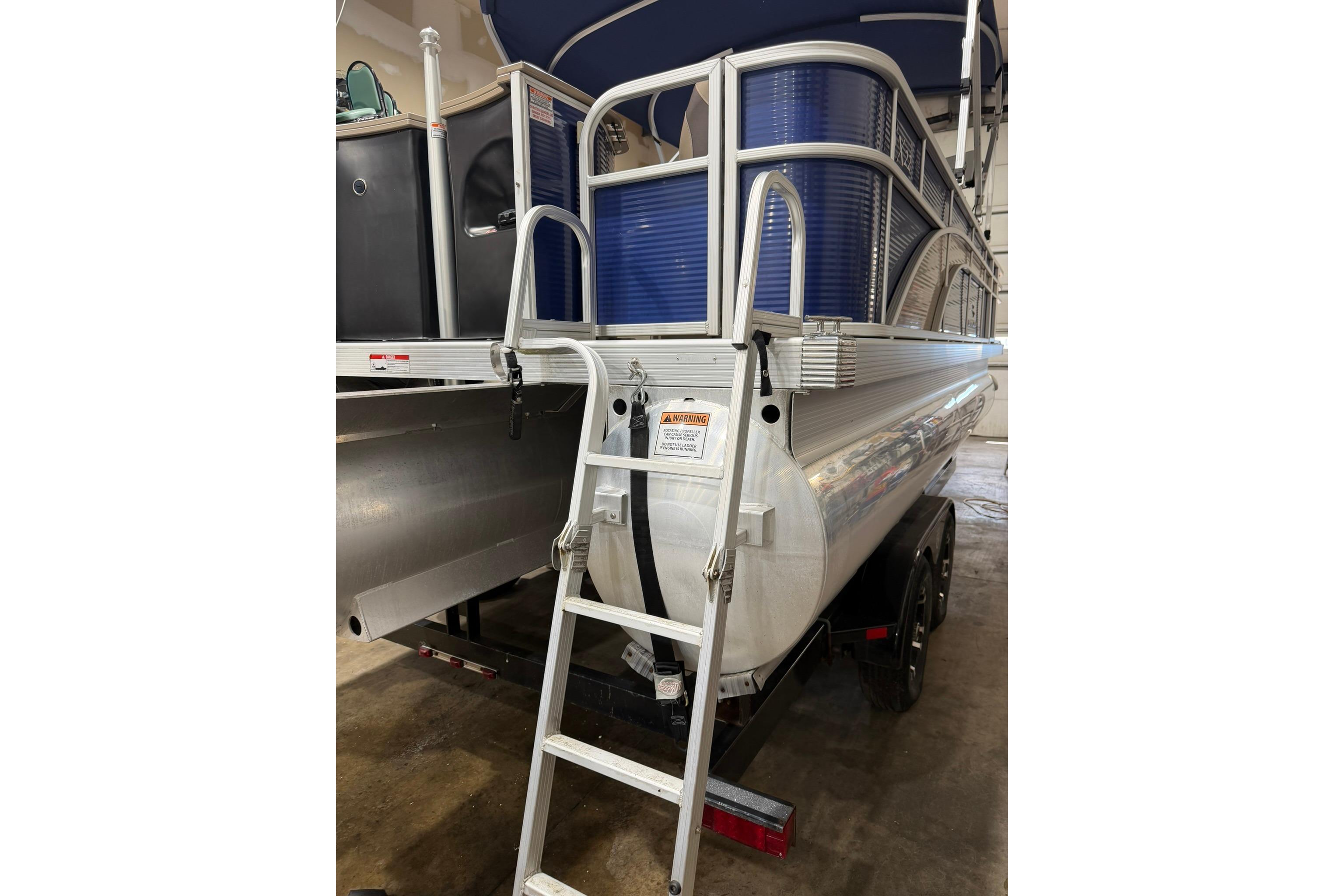 2020 Bennington SX 22 SFX pontoon boat with ladder in indoor storage.