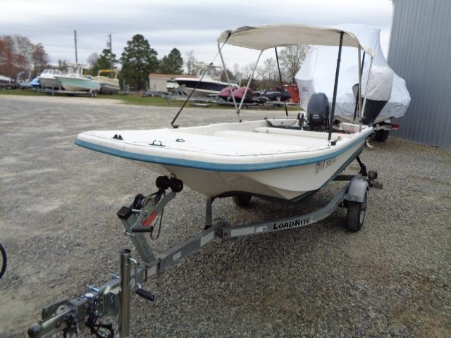 Sundance K14T 2010 boat on trailer with canopy, parked outdoors.