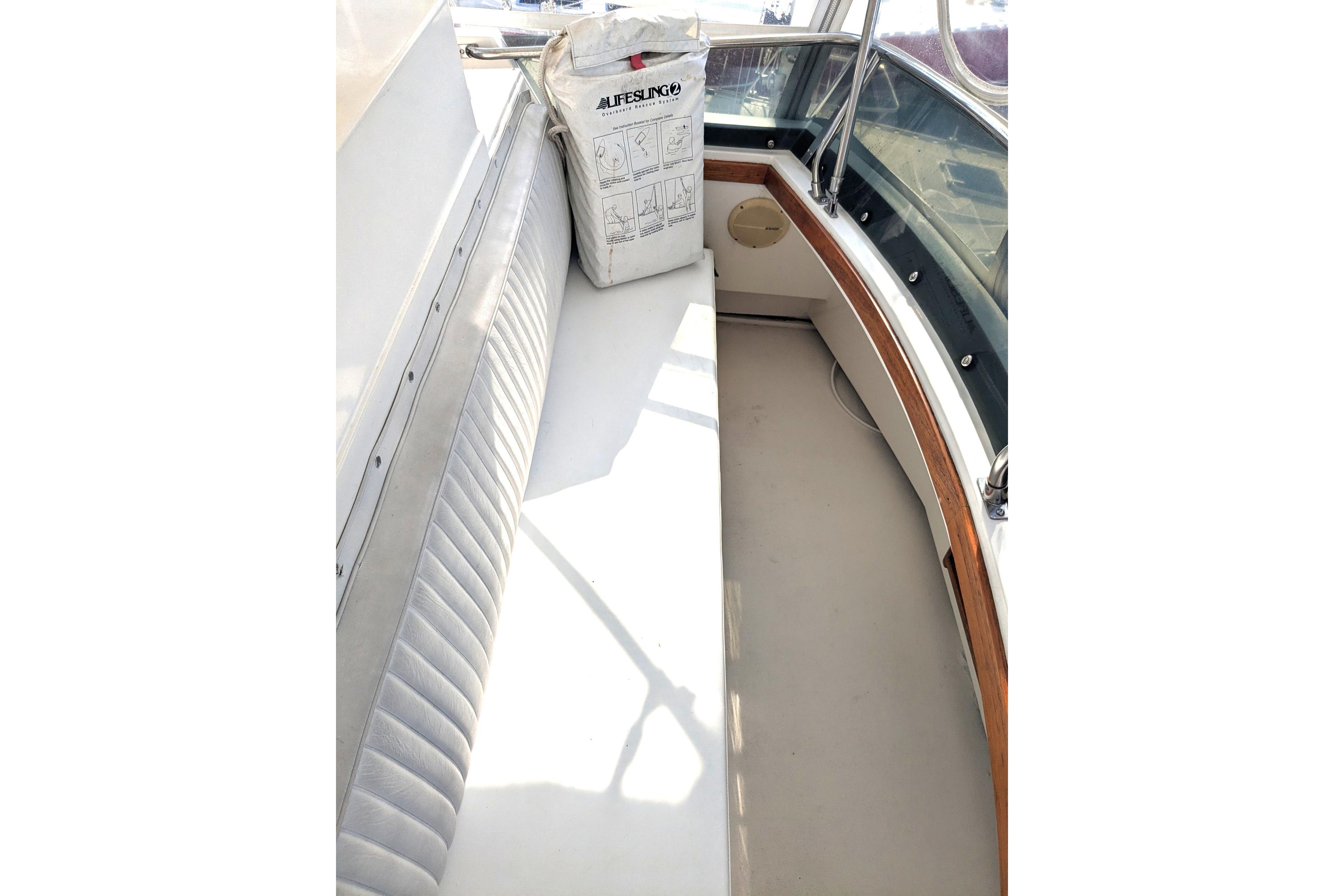1988 Cape Dory 36 Flybridge Sedan Trawler interior with cushioned seating and life-saving equipment.