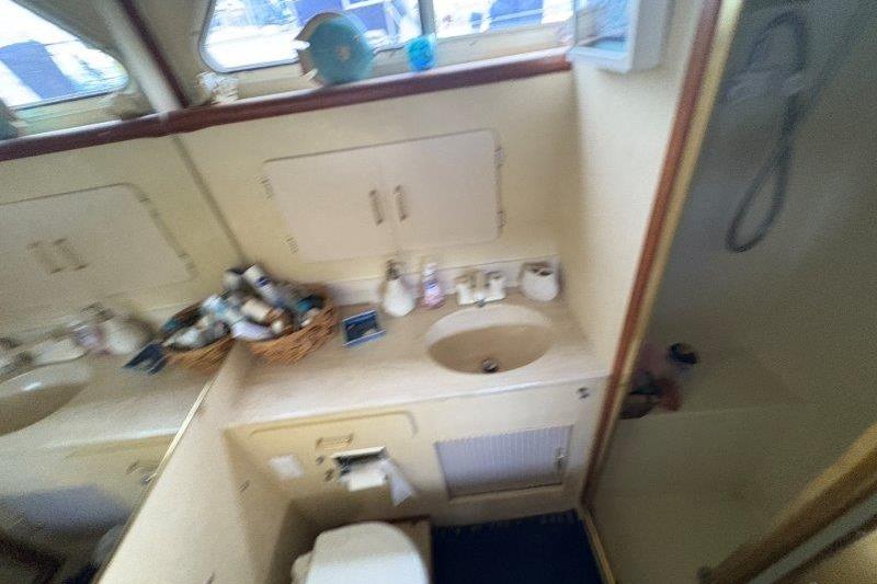 1987 Tollycraft 34 Sundeck Motor Yacht bathroom with sink, shower, and toiletries.