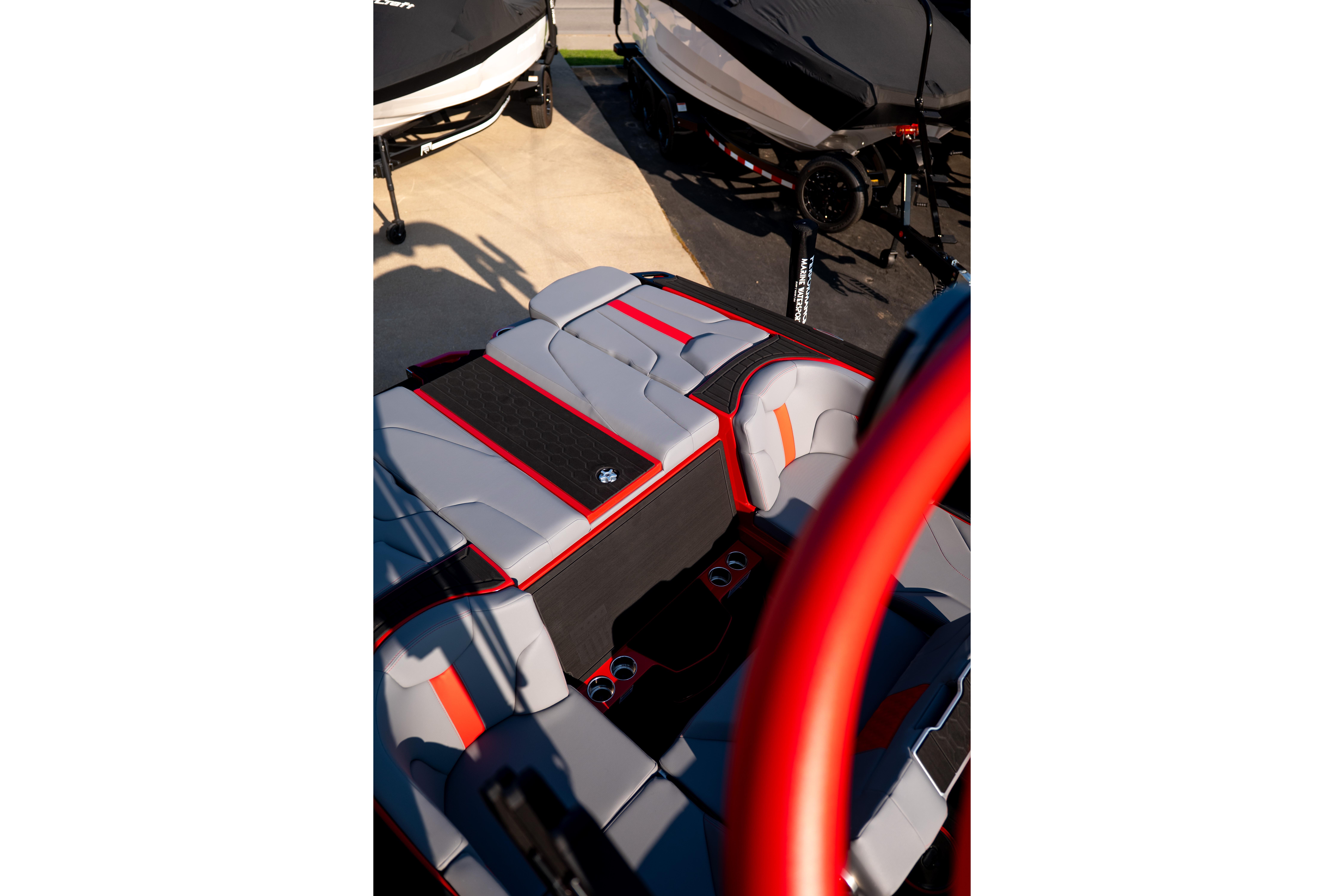 2027 MasterCraft XT24 boat interior with red and gray seating, parked on a trailer.