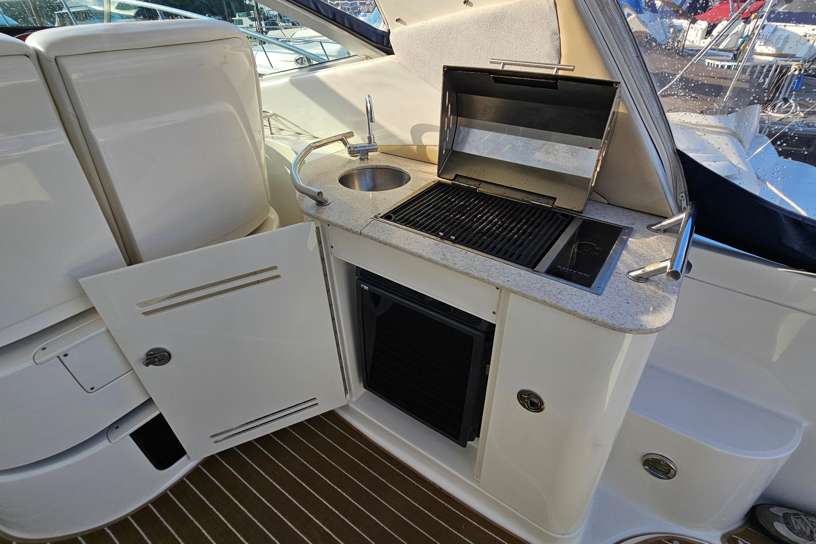 2008 Sea Ray Sundancer 350 yacht kitchenette with grill, sink, and storage.