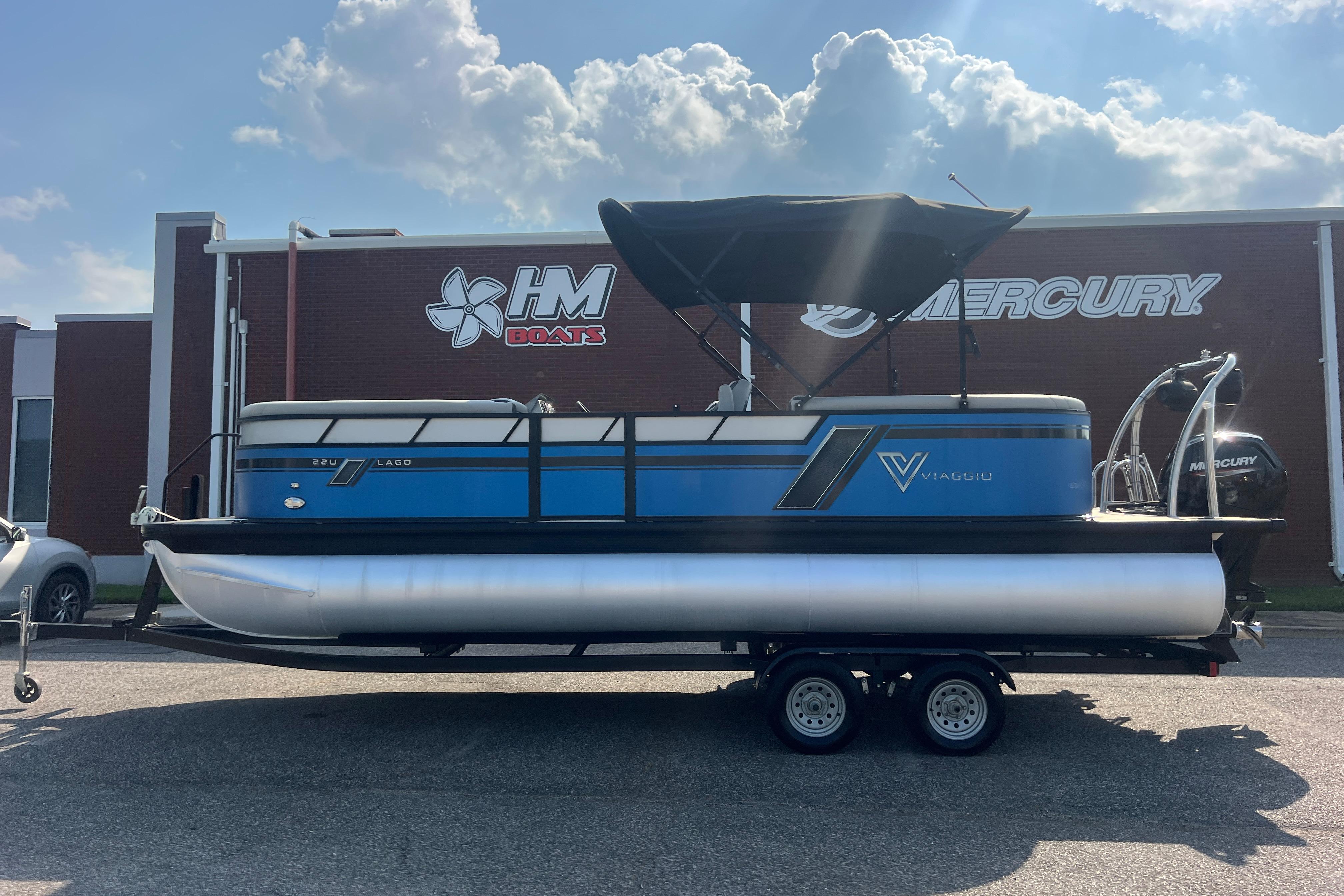 2022 Viaggio Lago V-U 22 pontoon boat on trailer, parked outside HM Boats dealership.