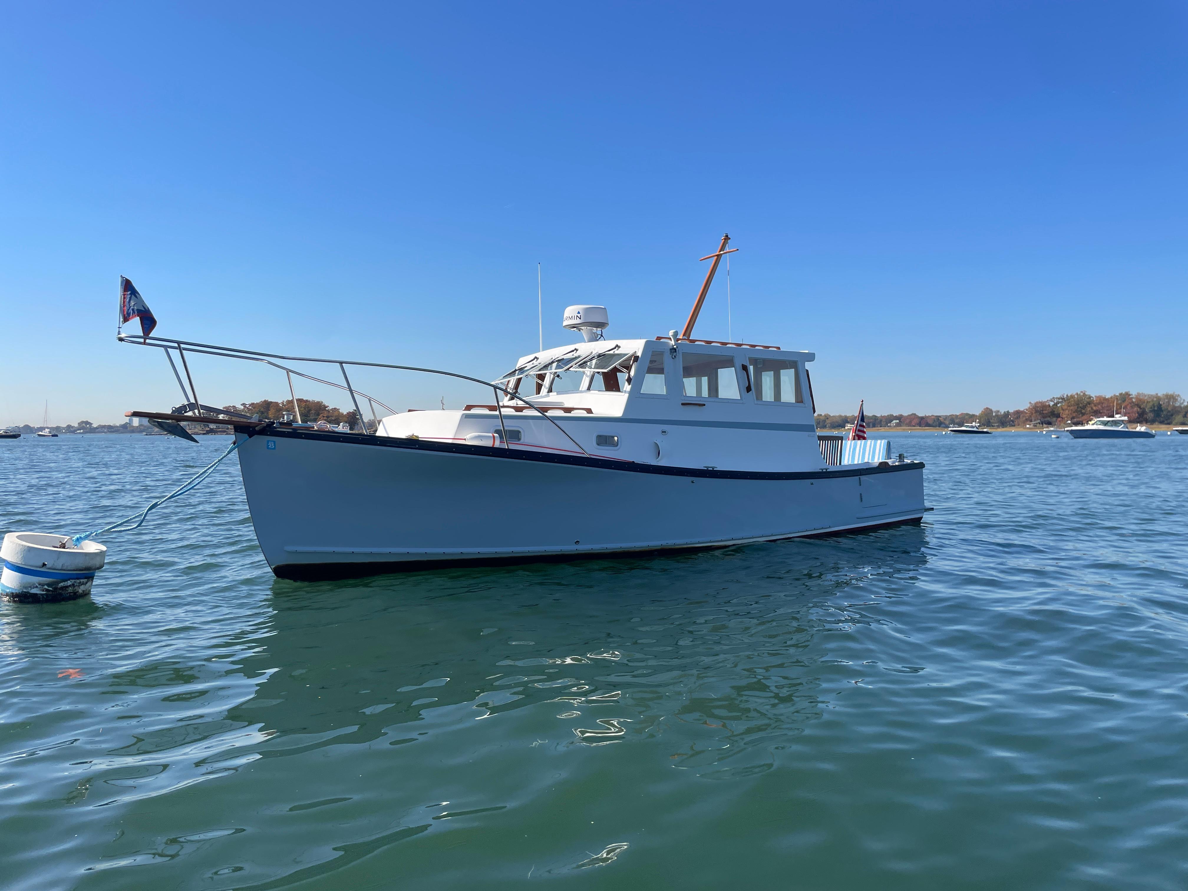1988 Ellis 28 boat on calm water under clear blue sky.