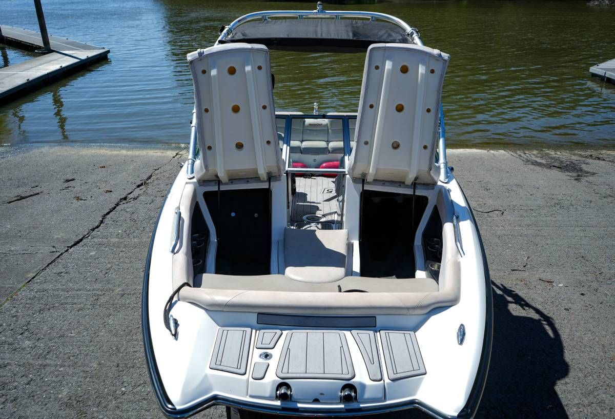 A 2007 MasterCraft X-45 boat at the shore with seats flipped up.