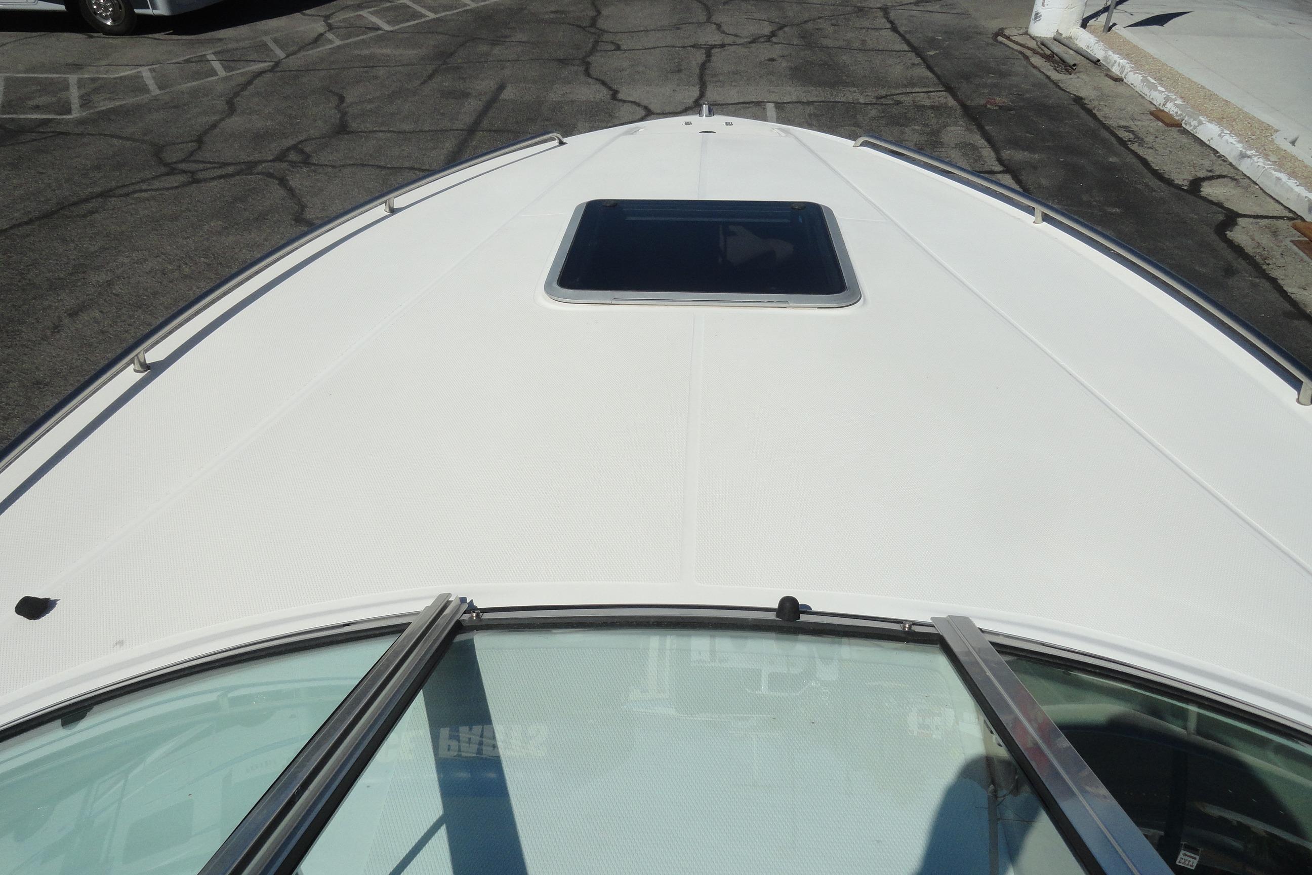 2001 Chaparral 265 SSi boat deck with hatch, parked on asphalt.