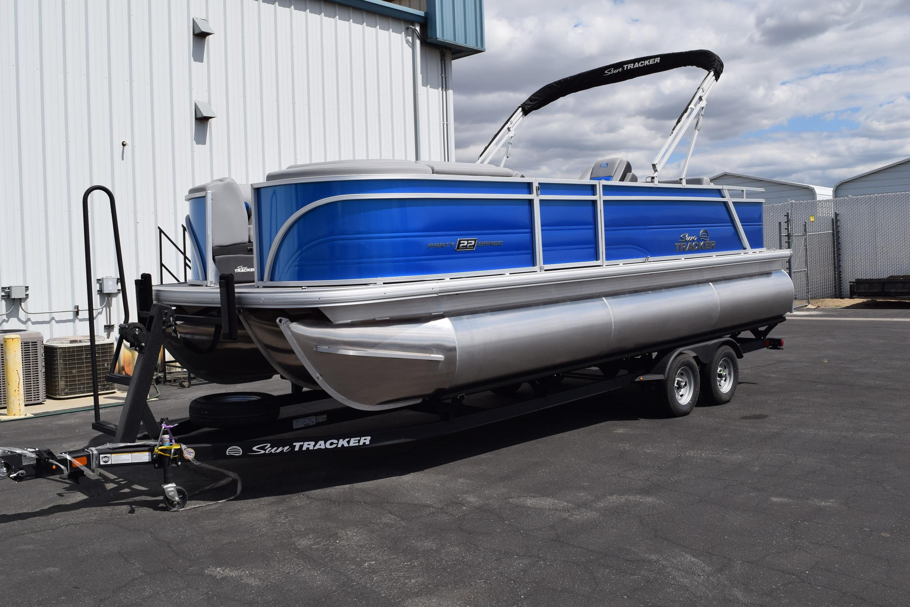 2026 Sun Tracker Party Barge 22 RF XP3 pontoon boat on trailer, parked outdoors.
