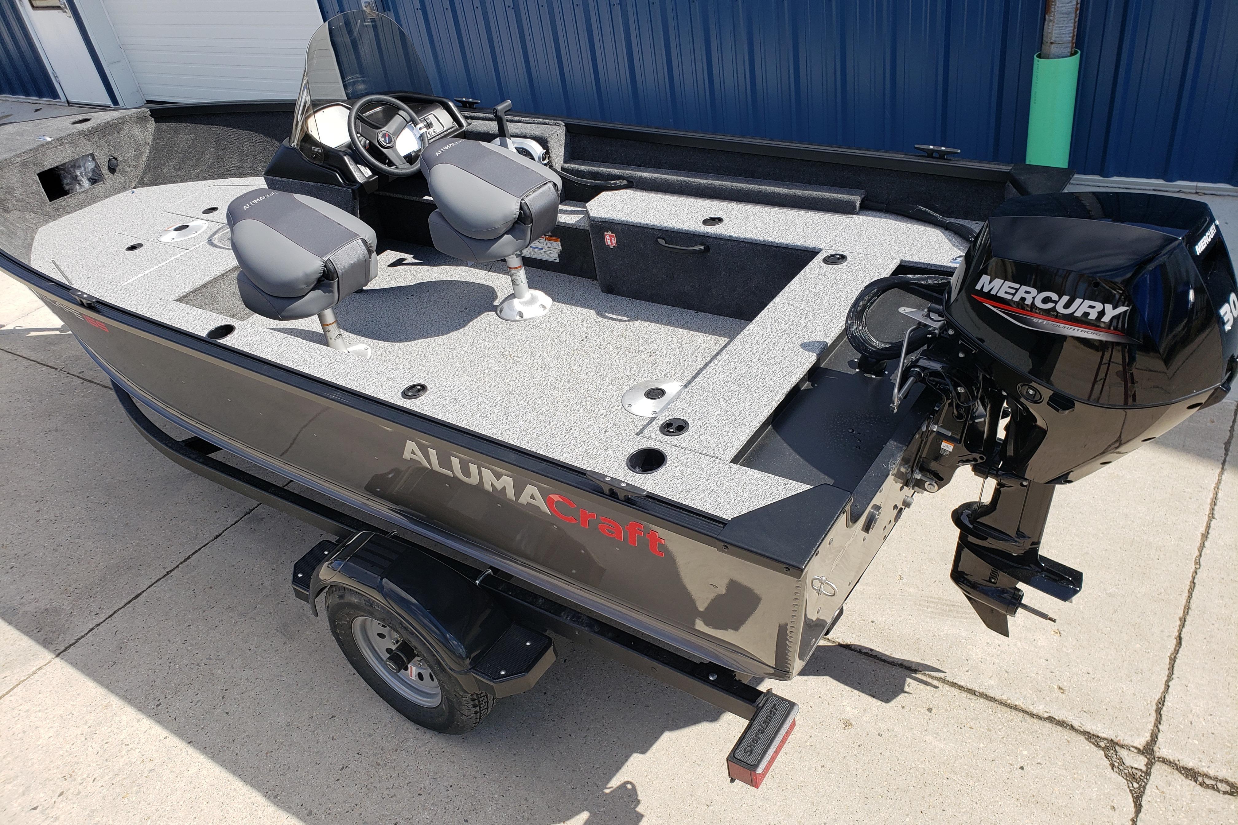 2026 Alumacraft Escape 165 CS boat with Mercury engine, parked on concrete.