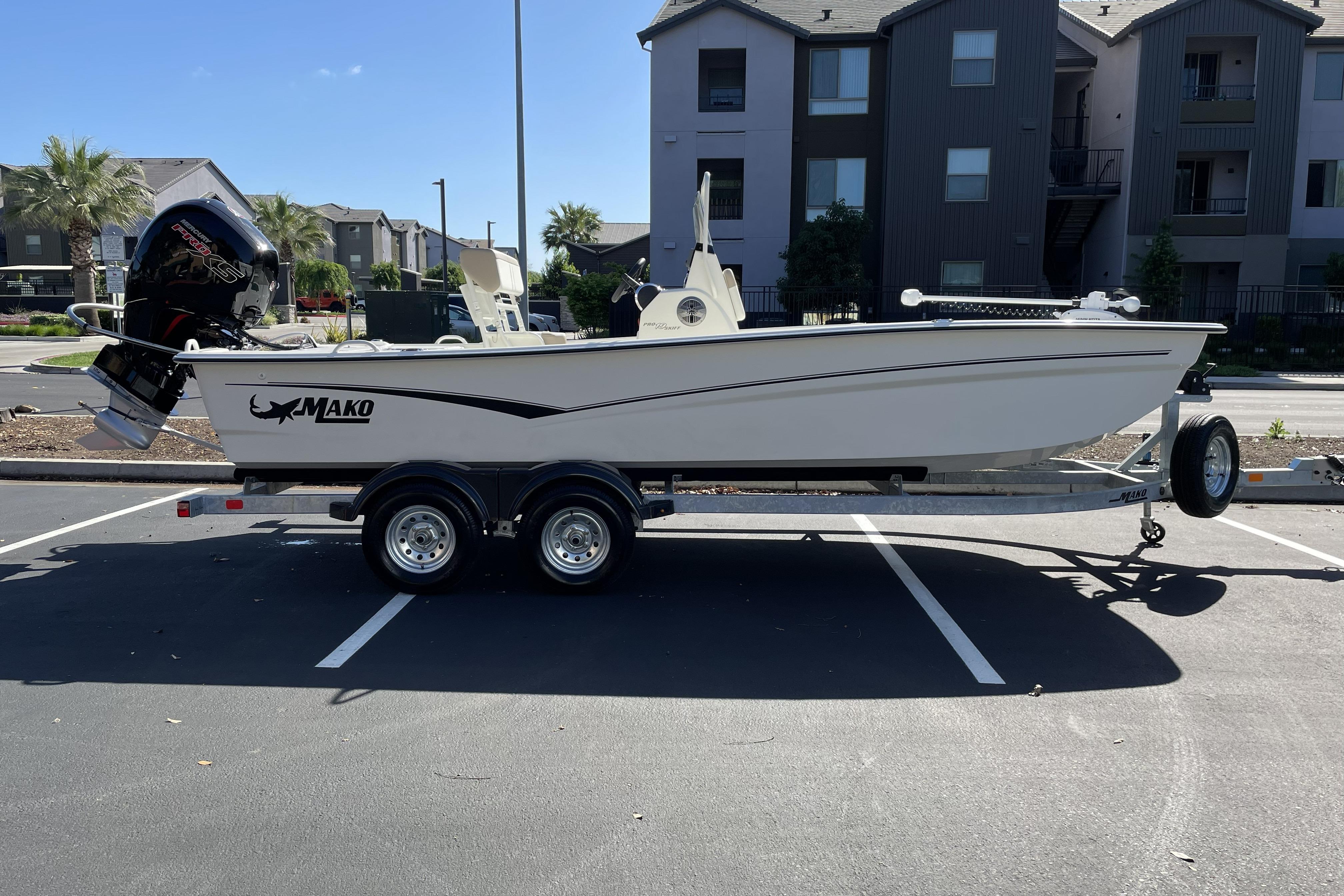 2026 Mako Pro Skiff 19 CC boat on trailer in parking lot.