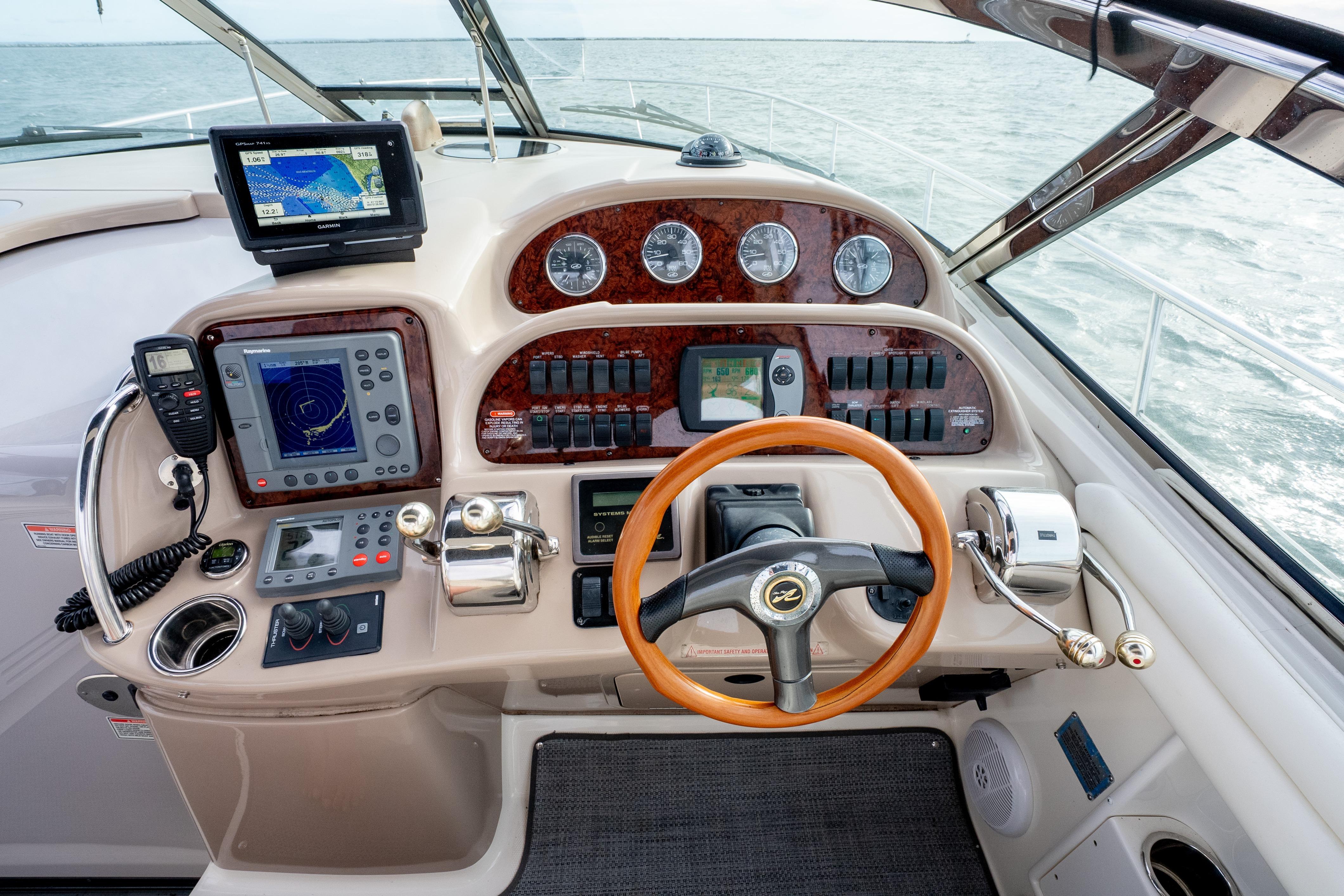 Helm of 2003 Sea Ray 360 Sundancer with navigation equipment and wooden steering wheel.