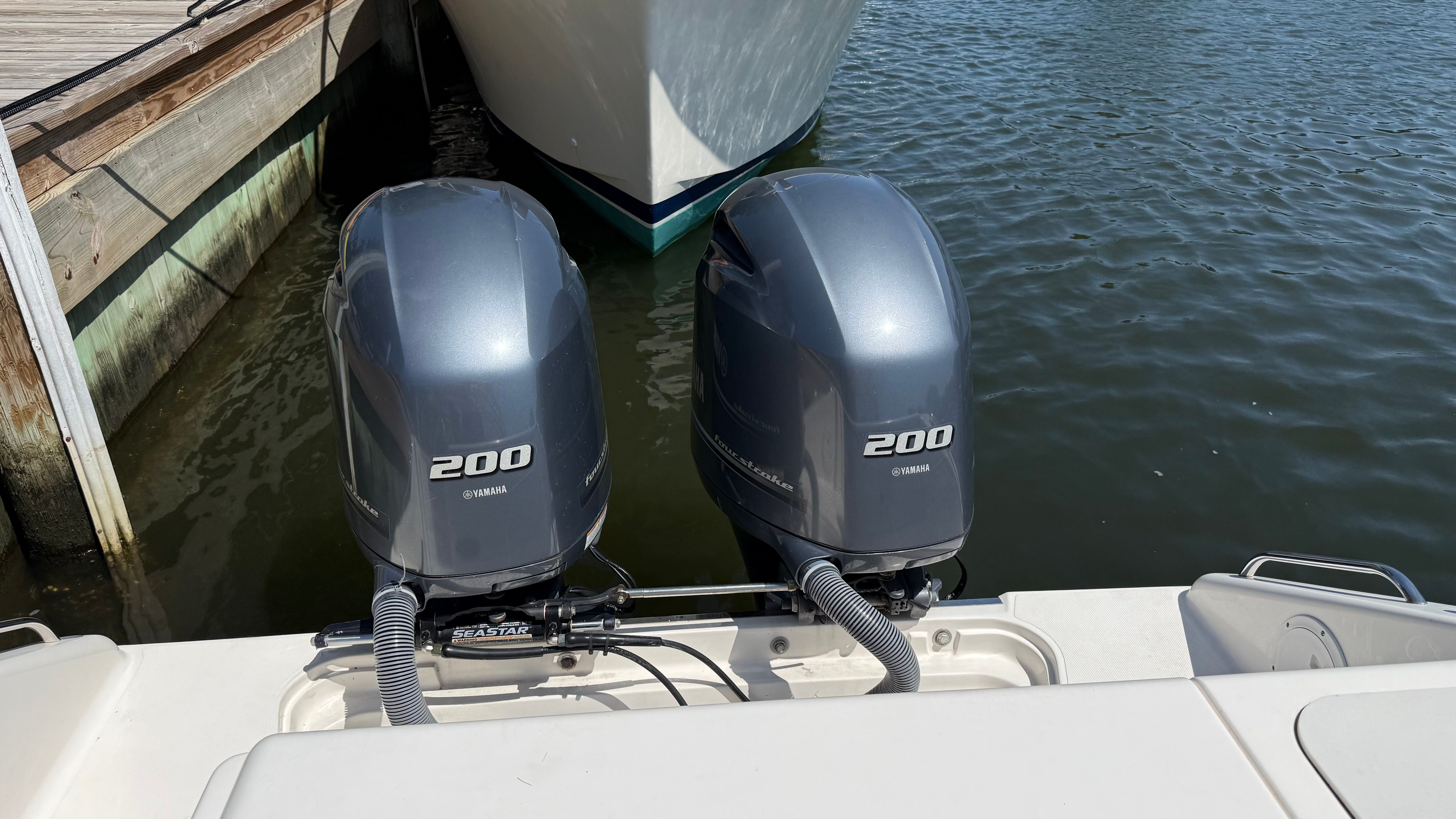 Two Yamaha outboard motors on a boat at the dock.