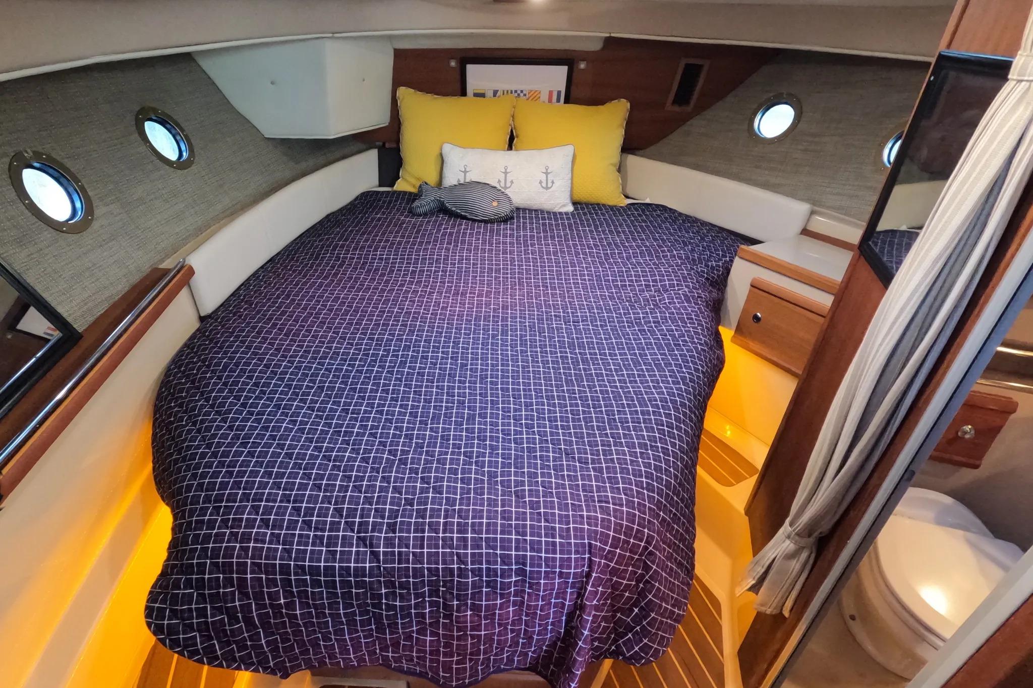 Cozy cabin interior of 2015 Ranger Tugs R-29 S with nautical-themed bedding.