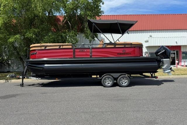 2026 Regency 230 DL pontoon boat on trailer, red and black design, parked outdoors.